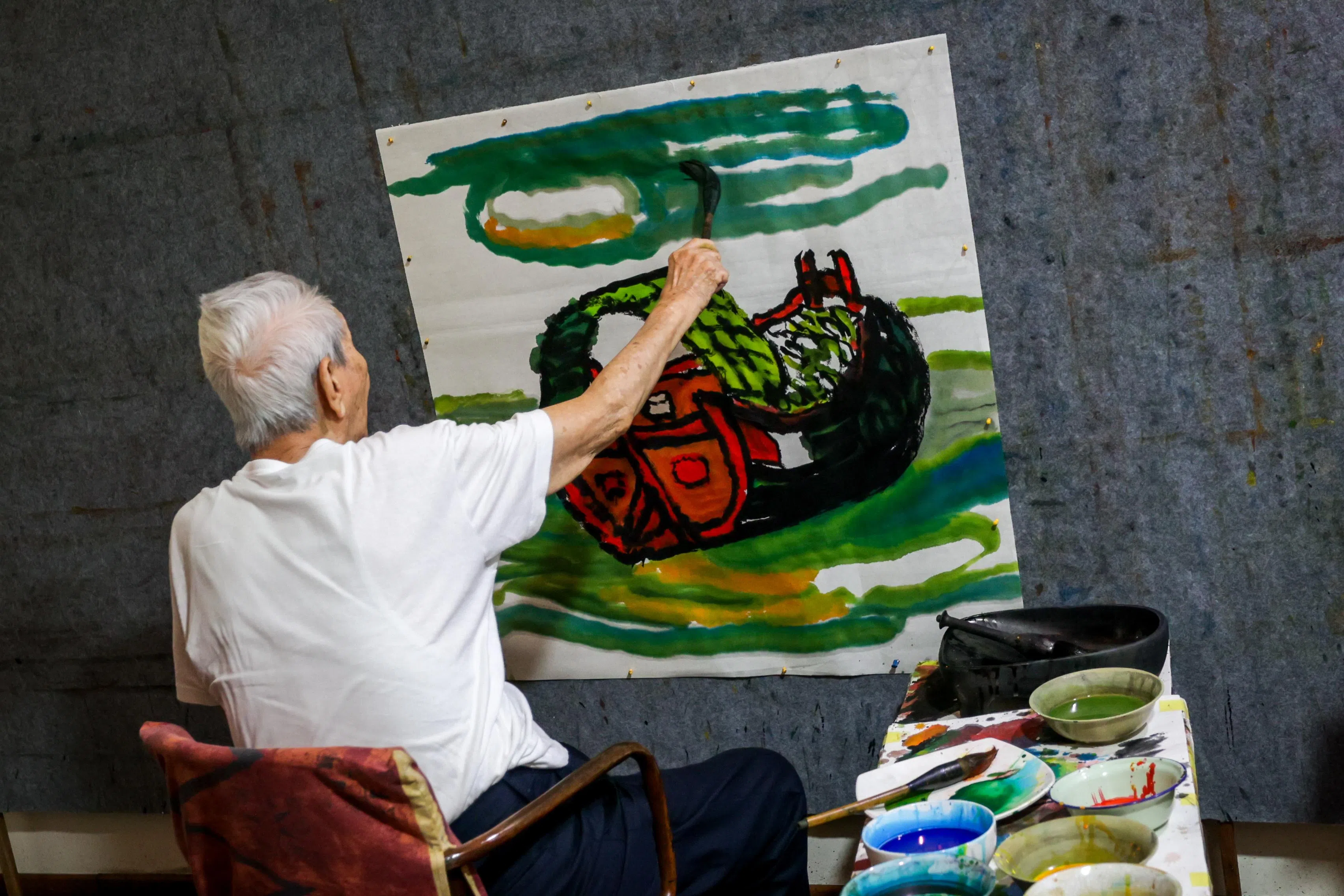 林子平在镜头凝视下，气定神闲，一笔到底完成这幅驳船画作。（叶振忠摄）