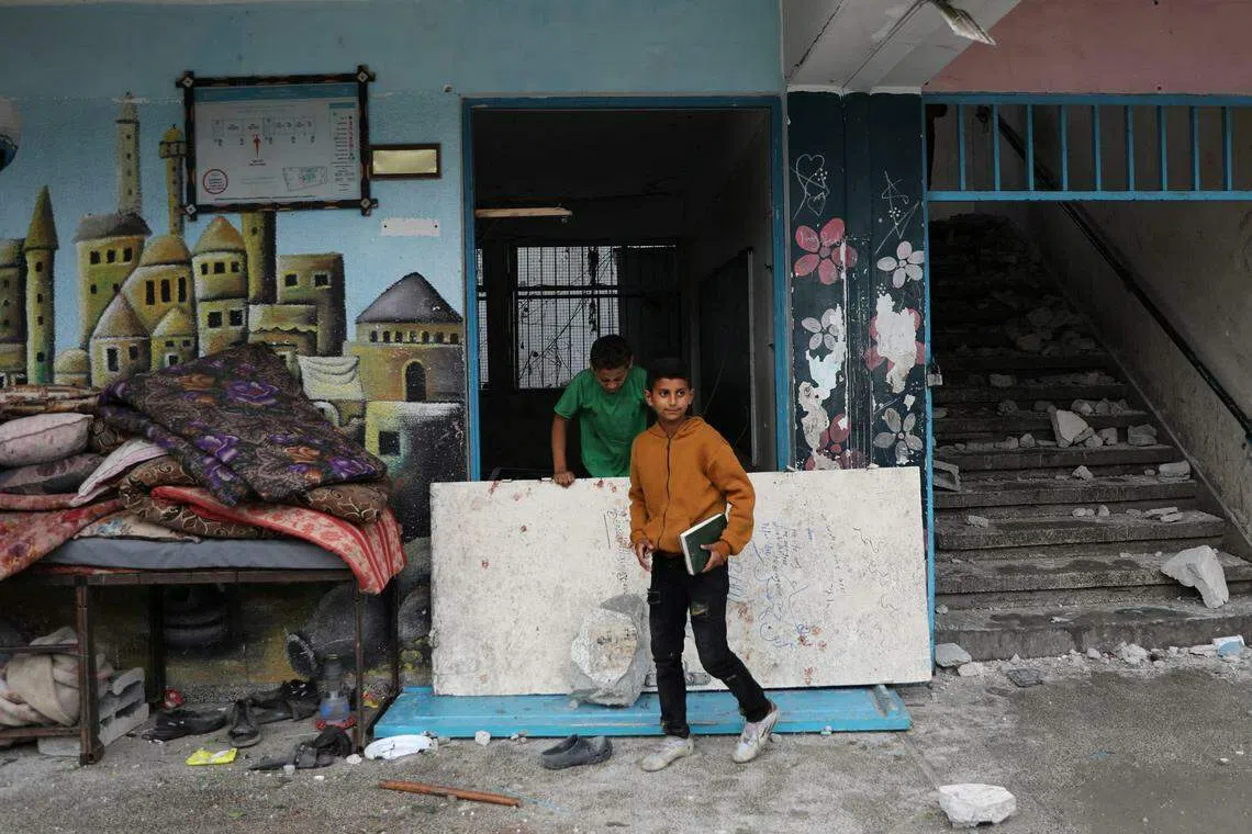 以色列袭击努塞拉特难民营后，在那里避难的民众检查建筑物的损毁程度。上个星期，世界卫生组织指出，在72小时里，五分之四以上的孩童至少整整一天完全没进食。（路透社）