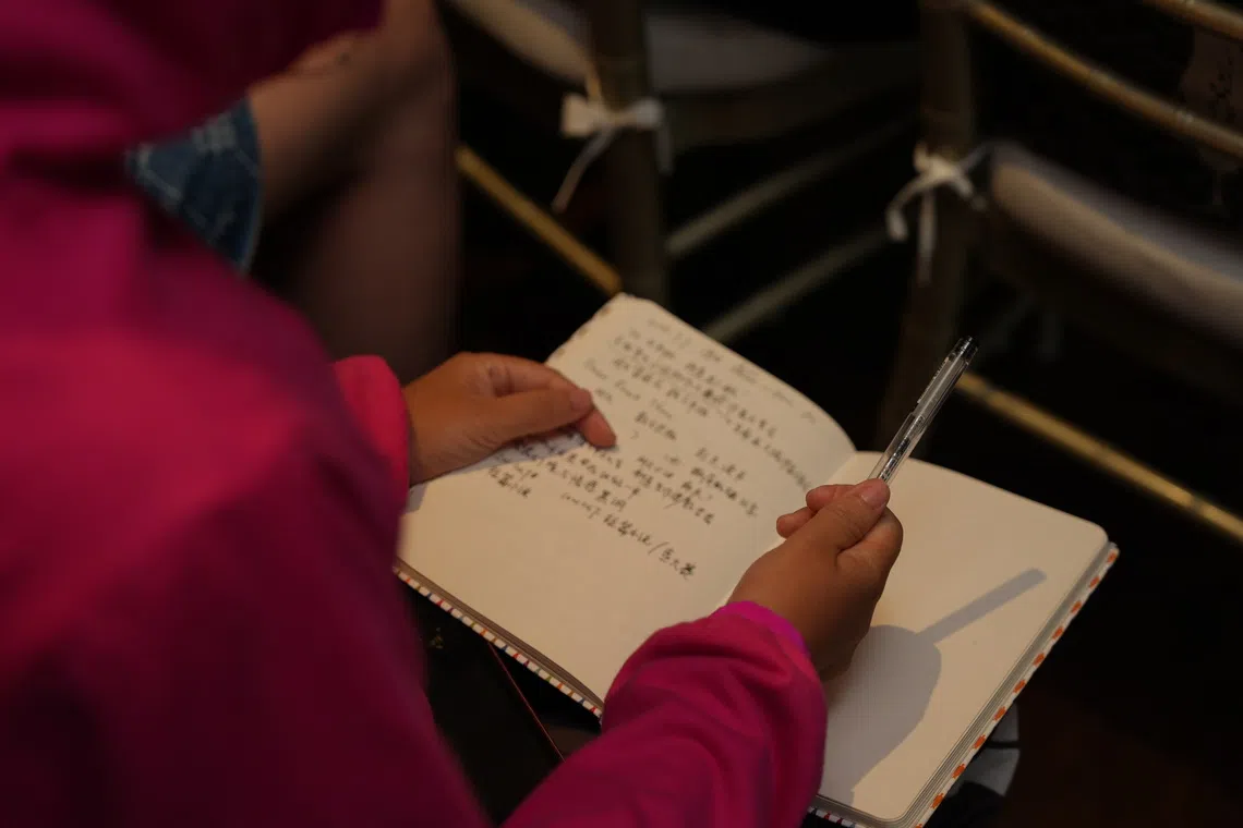 曼谷场活动，听众用纸笔记录关于文学创作的多元观点。