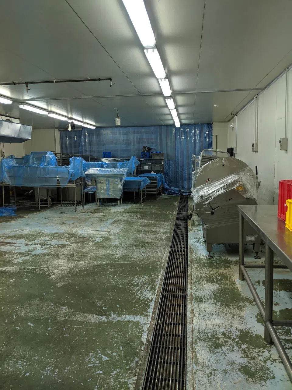 FOSP公司把货仓当成食品加工室使用，在当局封锁货仓后，还让员工偷偷进入清理现场，重新摆放设备，并用塑料布包起来。（新加坡食品局提供）