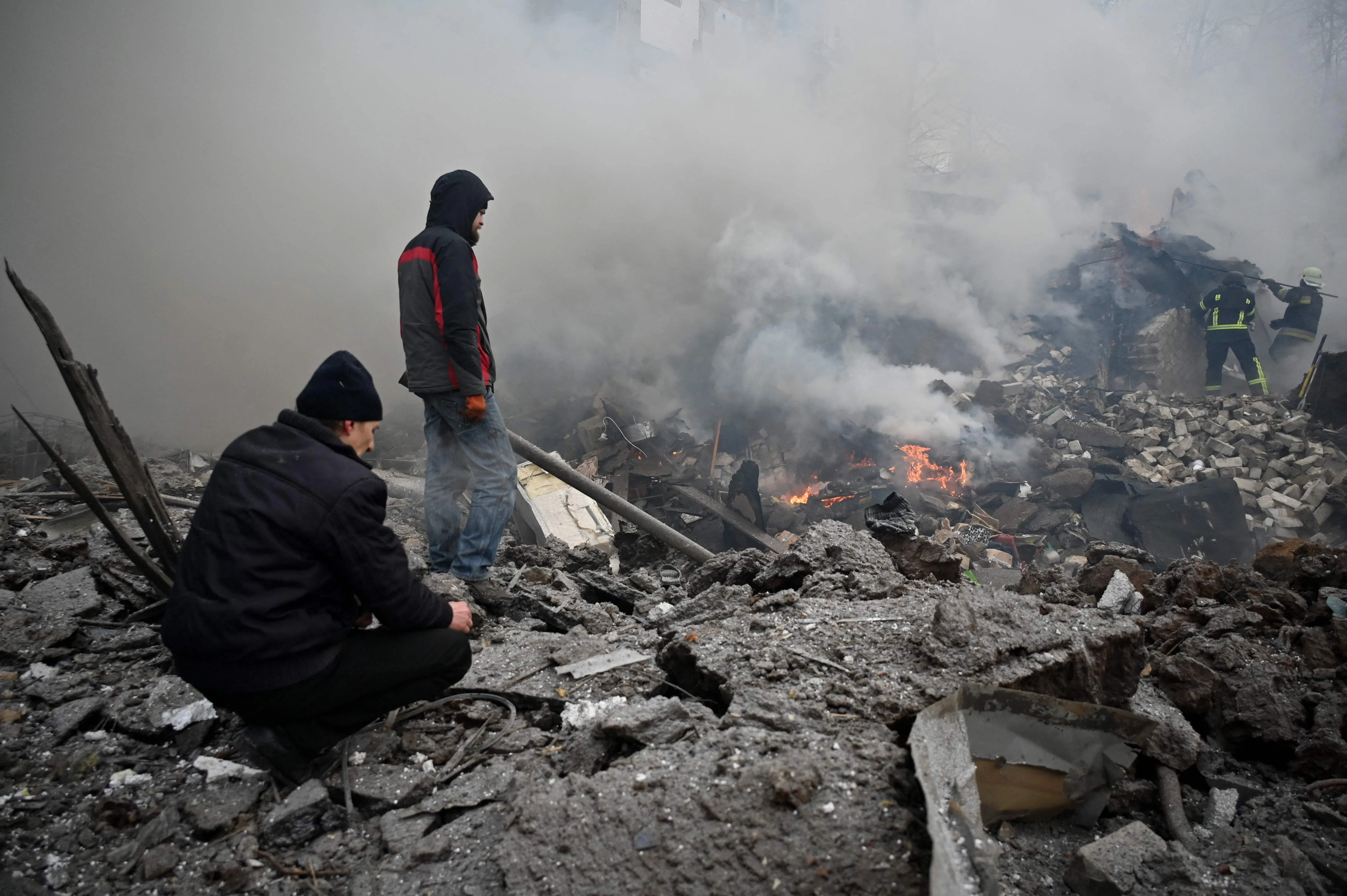 自俄乌战争爆发后，乌克兰境内多地被炮火炸毁，该国急需大笔资金重建家园。图为哈尔科夫居民站在废墟间。（法新社）