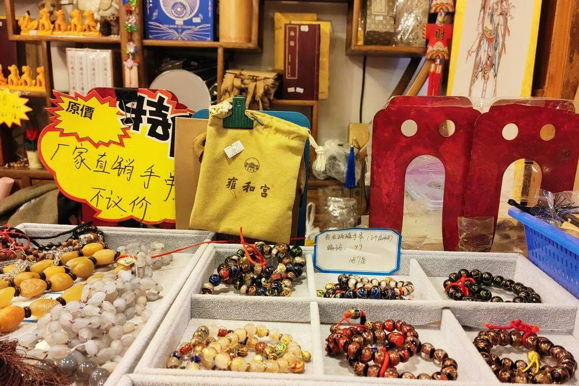 爆红的手串让雍和宫大街上的商铺嗅到商机，商家纷纷标明出售“香灰琉璃手串”。（孟丹丹摄）