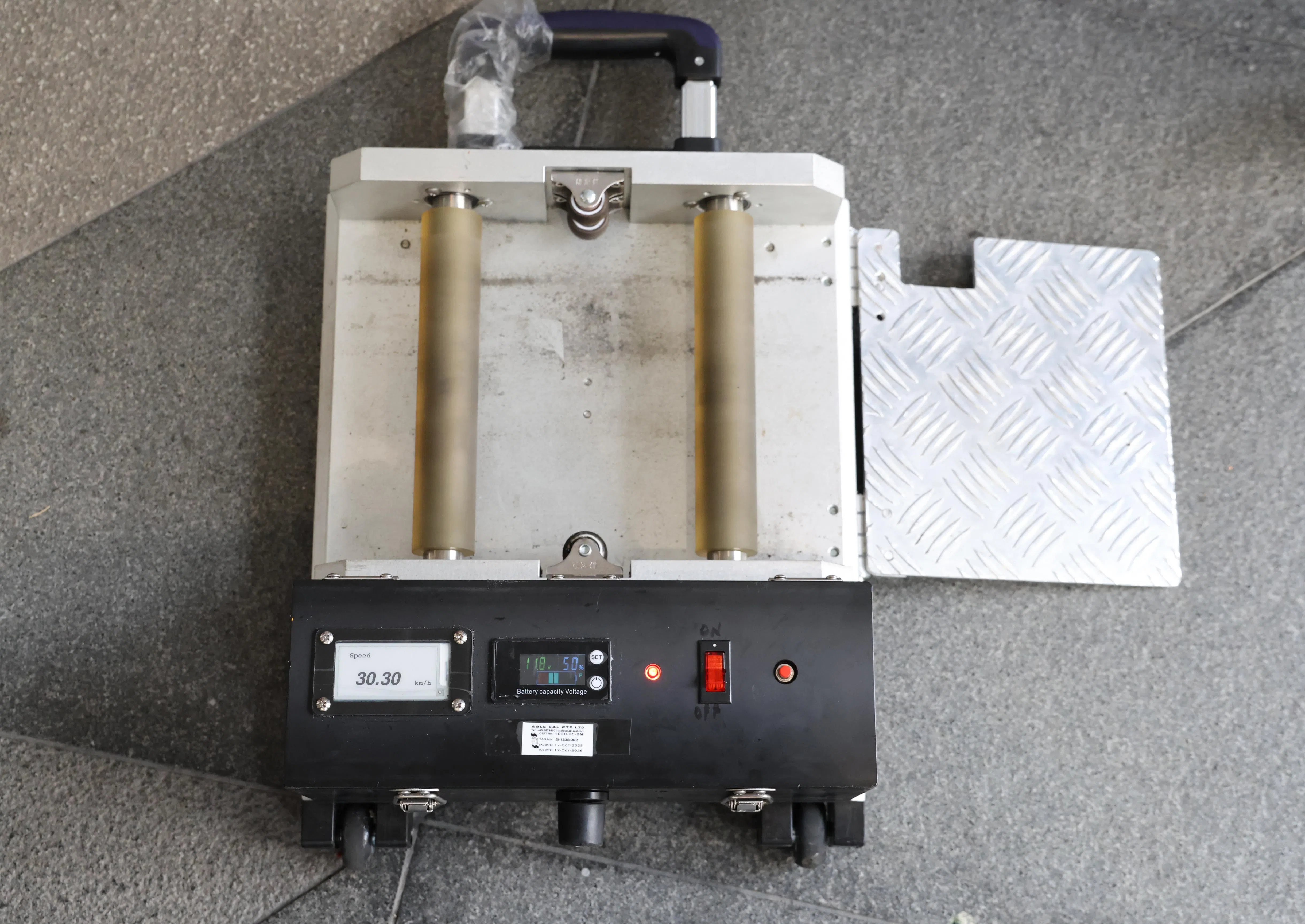 车速侦测装置中间有两个滚筒，让执法人员放上代步工具的后车轮，前方则有显示屏，数秒内便可测出代步工具的最高时速。（梁麒麟摄）