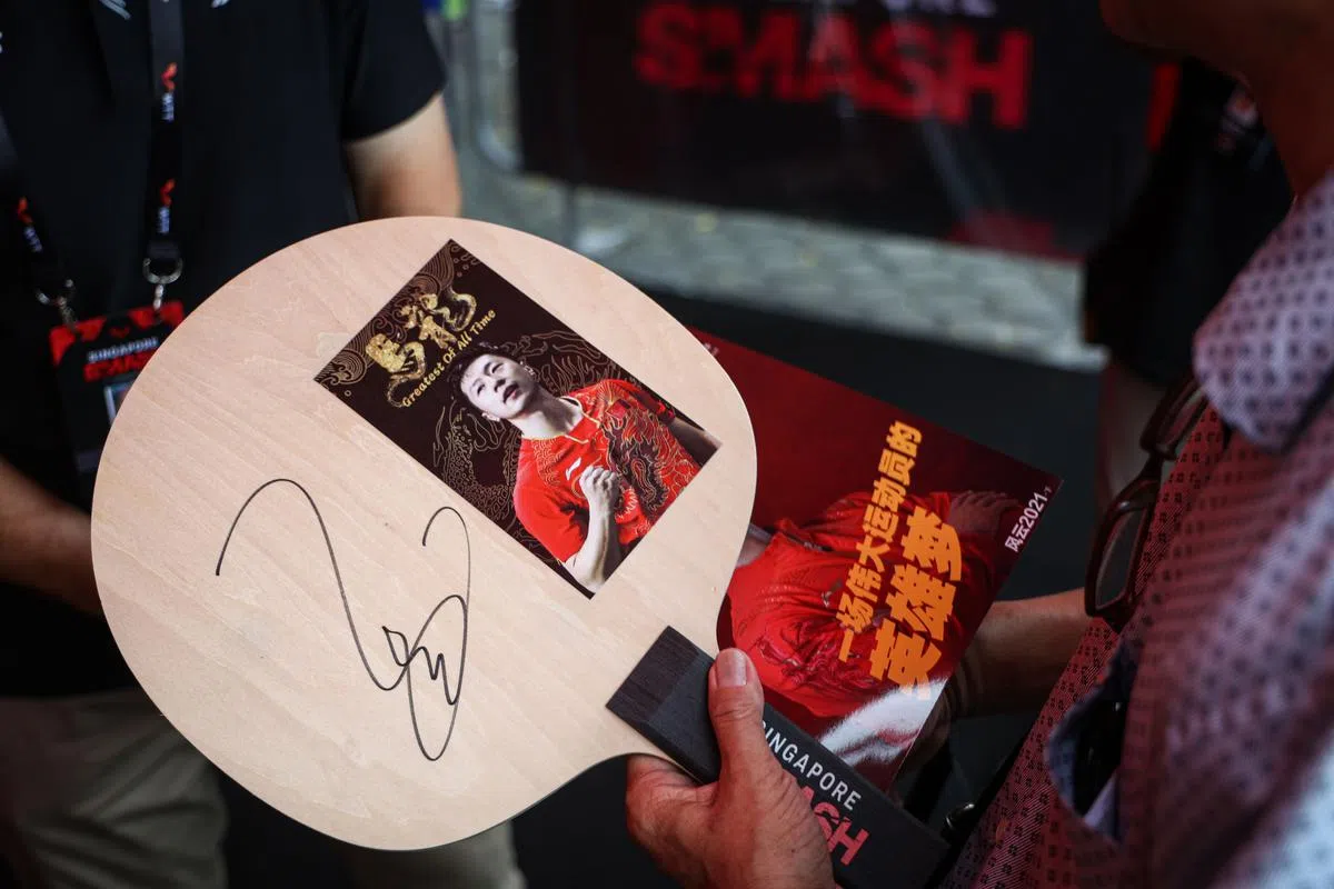 本地老球迷汪家良向记者展示他获得的马龙签名。（李健玮摄）