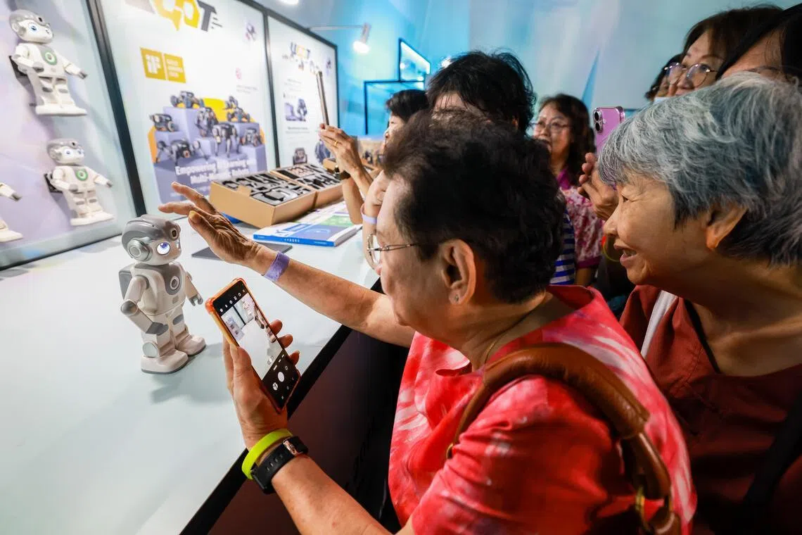 机器人节活动吸引不少乐龄人士，他们了解和体验了如何与机器人互动。（陈斌勤摄）