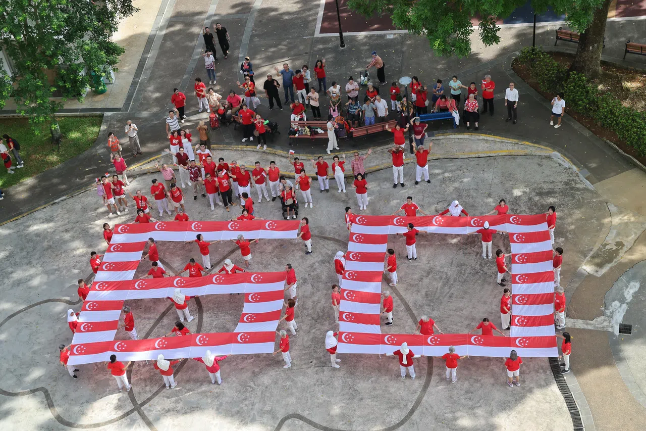 武吉甘柏居民用41面新加坡国旗组成“60”数字，象征社区团结，表达爱国情怀。（唐家鸿摄）