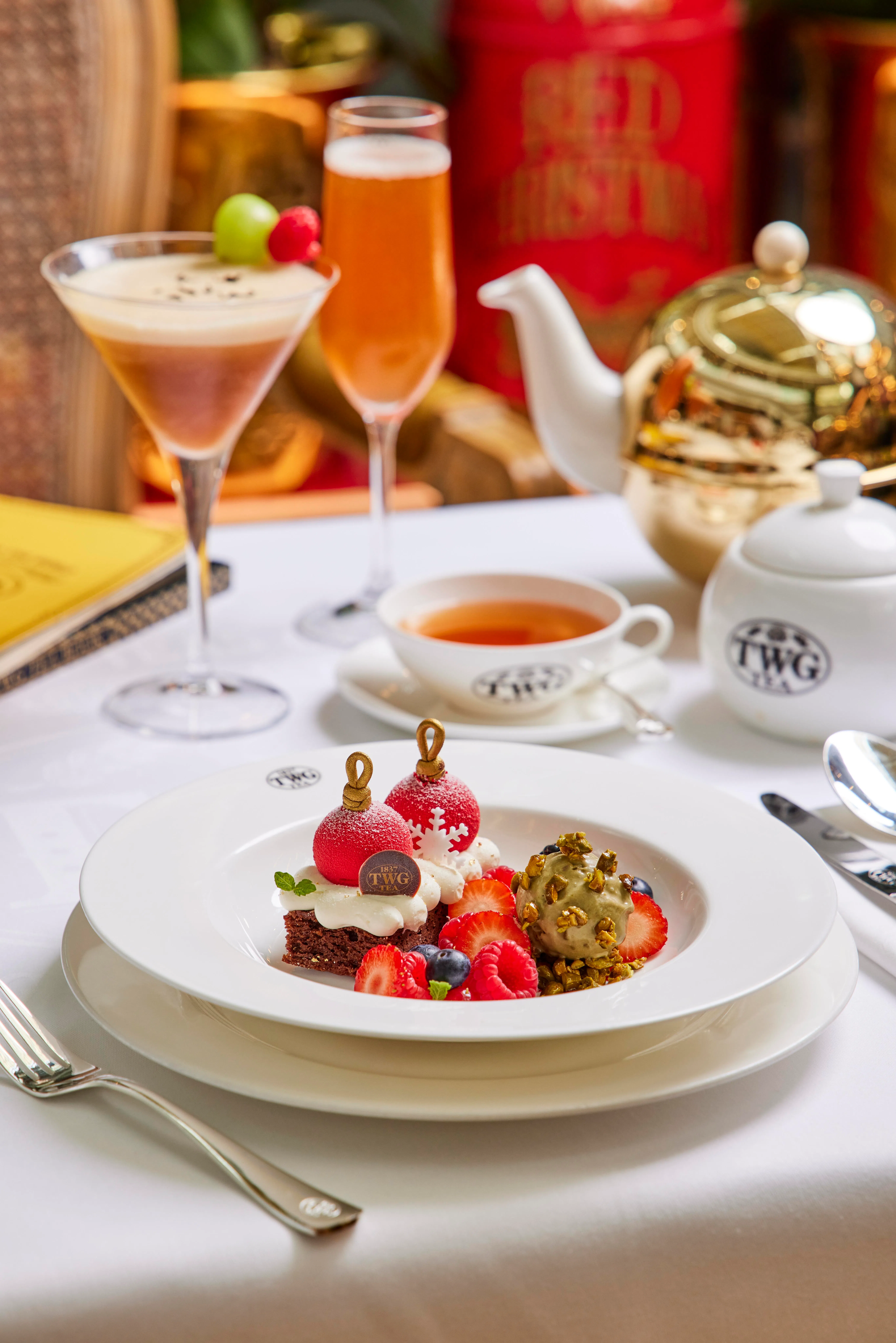 巧克力香蕉布朗尼铺上香缇奶油与圣诞红茶树莓晶球，佐以焦糖开心果雪糕，点亮节日甜香。（品牌提供）