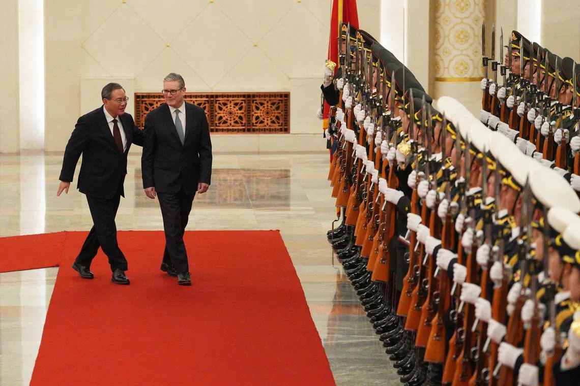 会谈前，中国总理李强（左一）在北京人民大会堂北大厅为英国首相斯塔默（左二）举行欢迎仪式。（路透社）