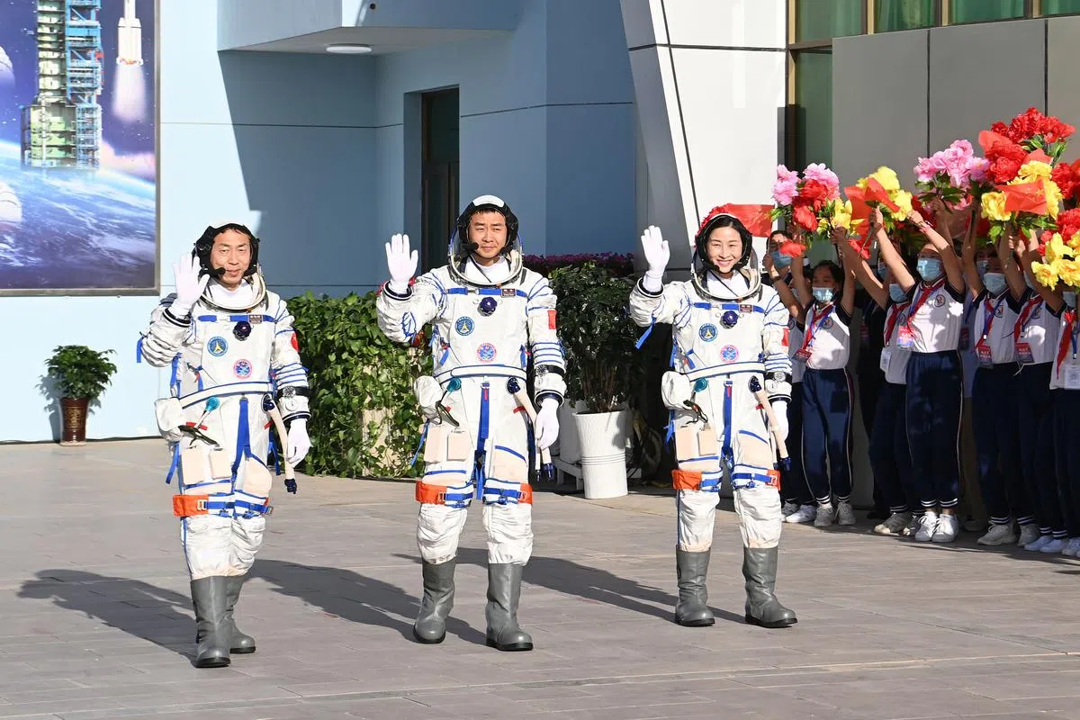 神舟十四号载人飞行任务航天员陈冬（中）、刘洋（右）、蔡旭哲（左）今早在进入返回舱前，于酒泉卫星发射中心问天阁广场参与出征仪式。（中新社）