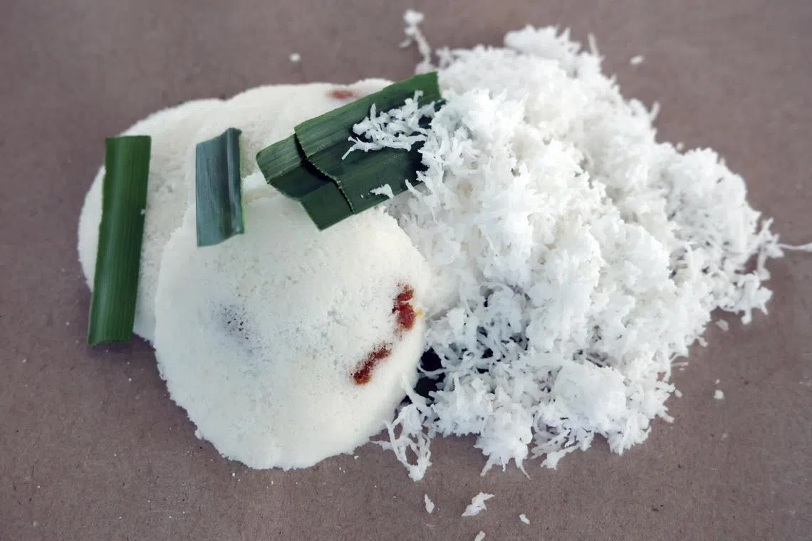 马来式嘟嘟糕Putu Piring，椰糖内馅，搭配稍带咸味的椰丝吃，别有风味。（梁麒麟摄）