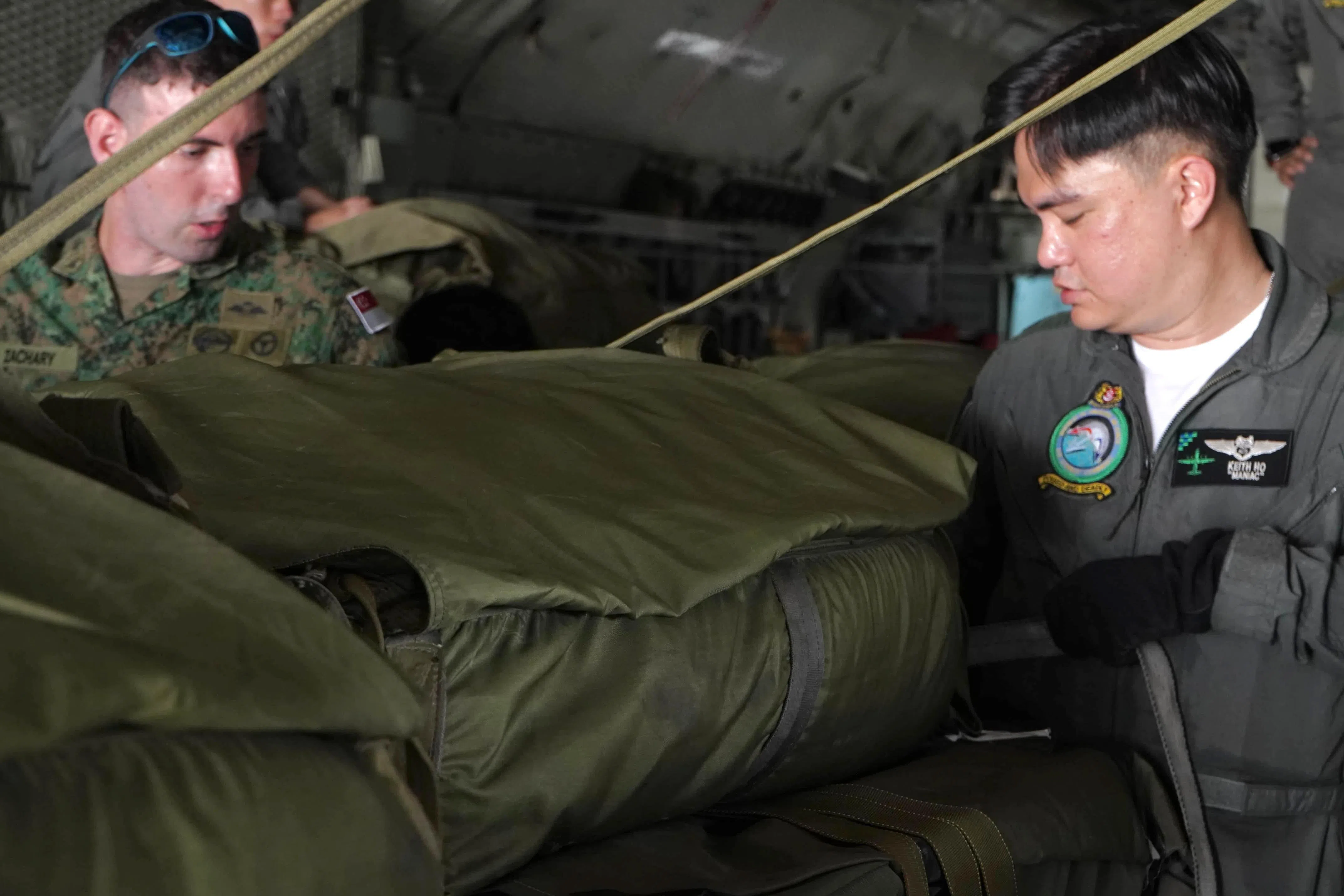新加坡武装部队第三运输营人员和空军部队C-130运输机机组人员，在机上为空投任务做准备。（国防部提供）