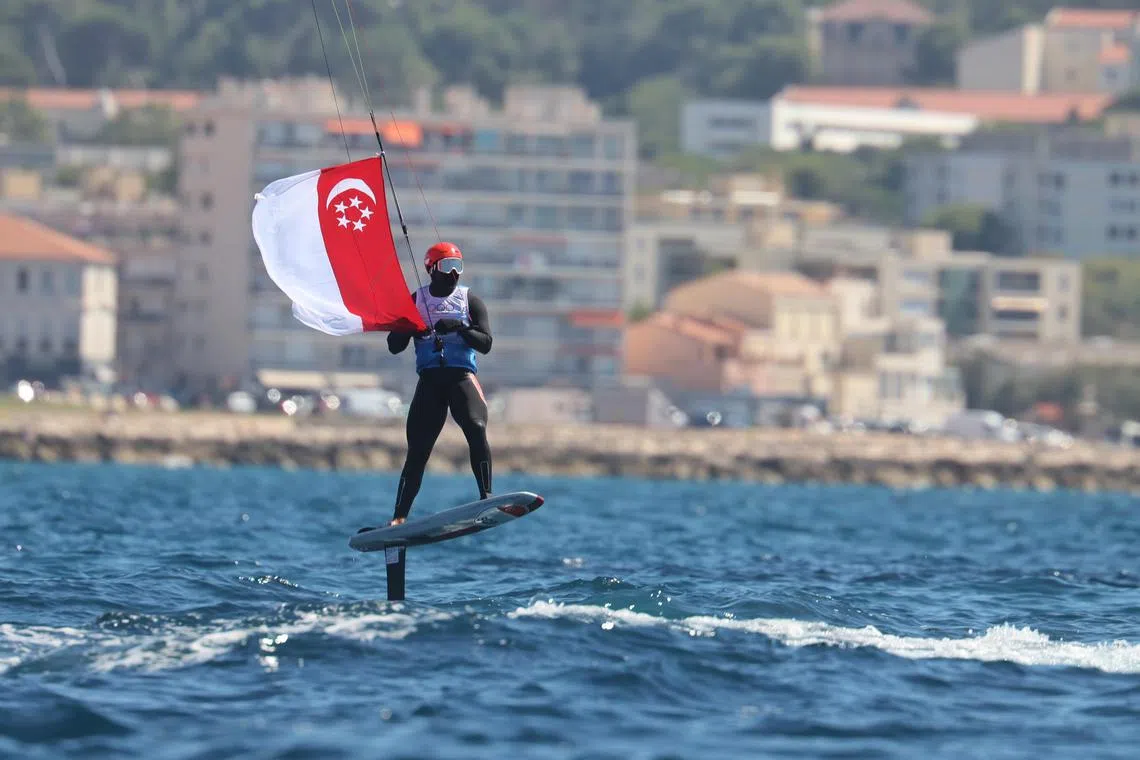 墨士廉在比赛结束后，将新加坡国旗系在风筝引线上，迎风返航。（谢智扬摄）
