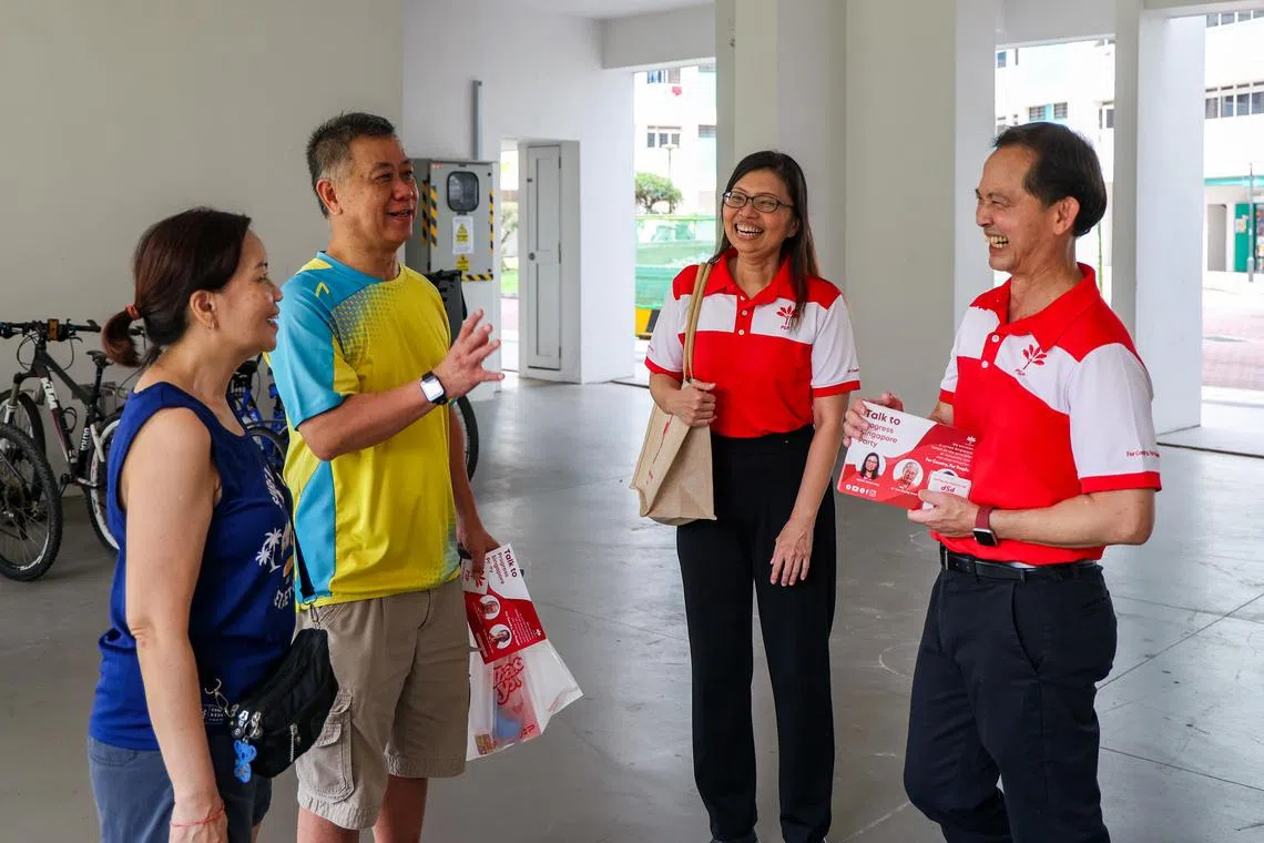 前进党秘书长潘群勤（右二）和中委梁文辉（右一）上个星期天上午，与约20人的前进党团队走访了蔡厝港2道的10座组屋和丰山台的有地住宅。（陈斌勤摄）
