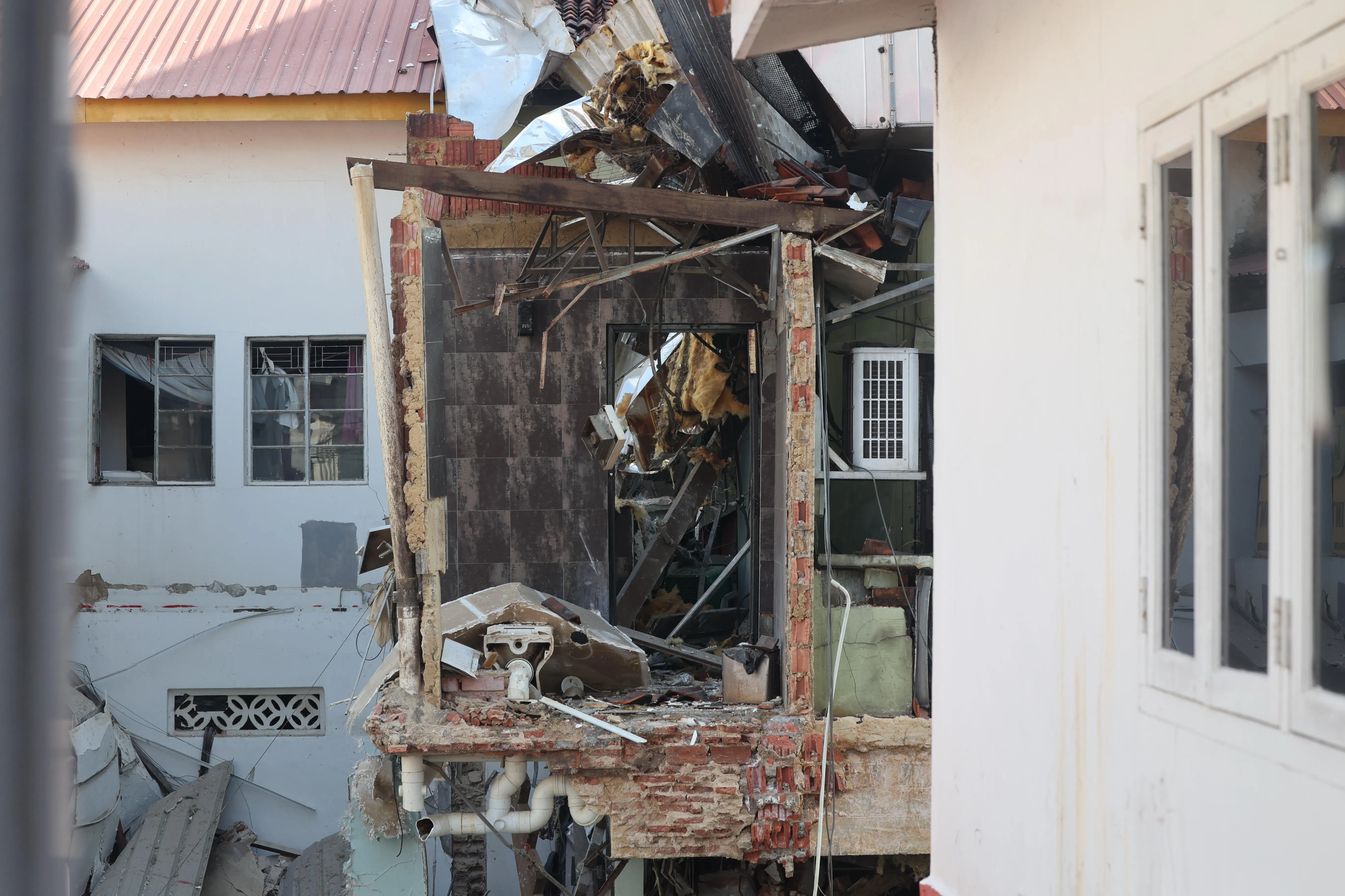 从对街的酒店窗口看过去，赛阿威路84号店屋厕所的一整面墙被震脱，只剩下一马桶暴露在外，犹如战争场景。（陈斌勤摄）