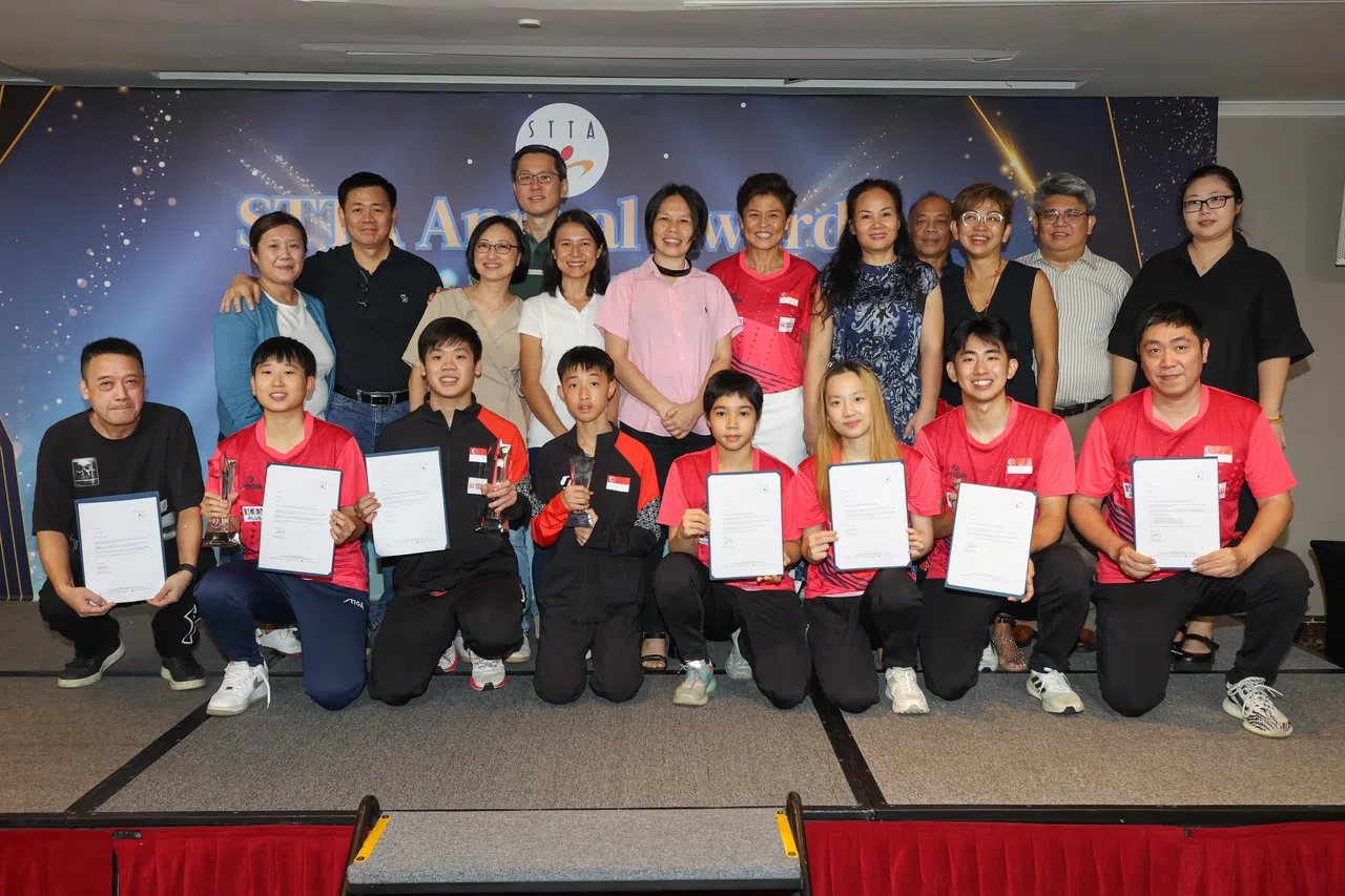 文化、社区及青年部兼永续发展及环境部高级政务次长吴函燕（后排左五）在台上和得奖运动员还有他们的父母合影，当晚得奖的运动员是周靖祎（前排左二起）、郭勇、梁城明、黎明映、舒麟茜、冯耀恩以及教练高宁。（陈心媛摄）