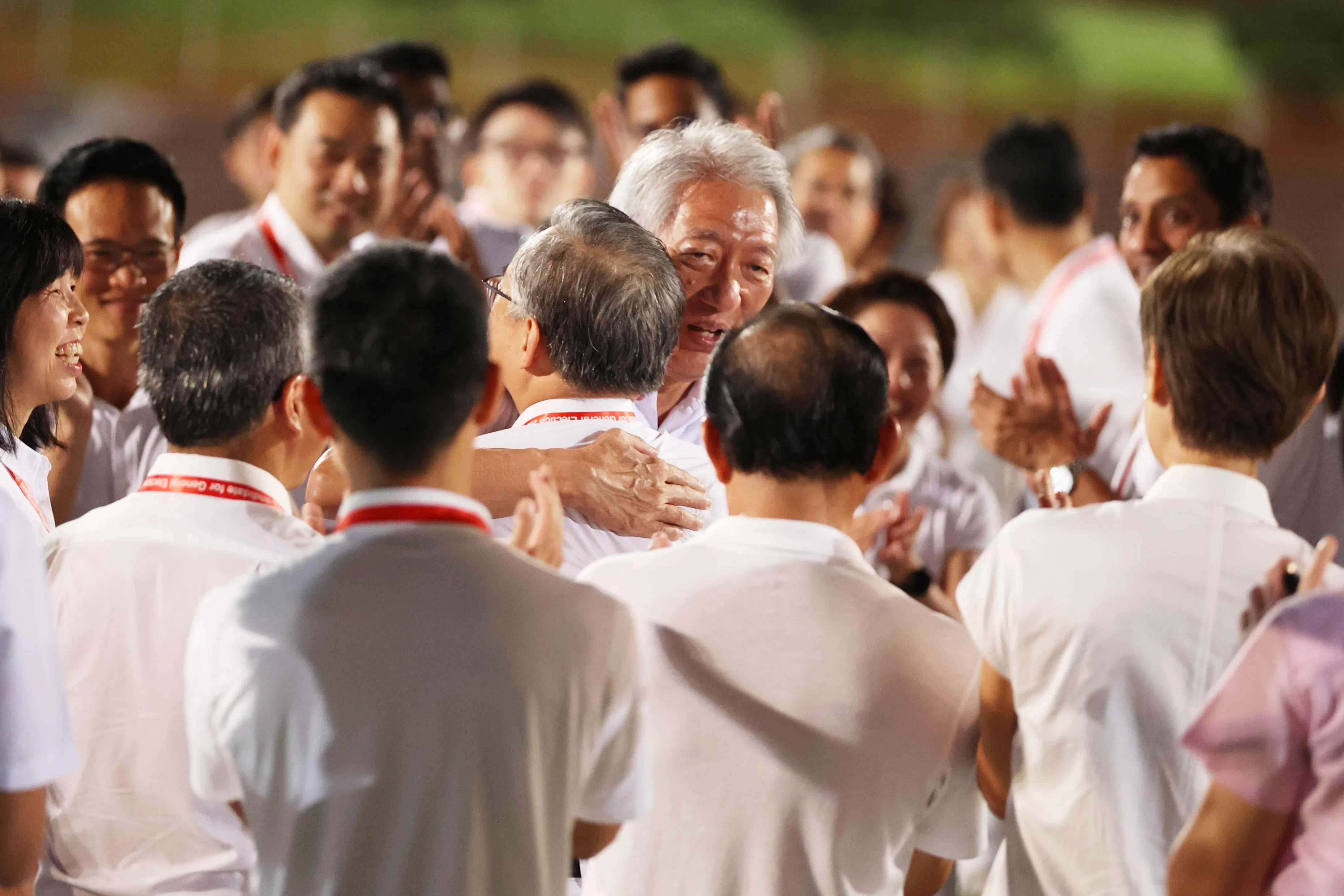 原白沙—榜鹅集选区领军部长张志贤（中间）引退后，由副总理兼贸工部长颜金勇（背对镜头）接手带领榜鹅集选区团队。等候正式结果出炉之前，张志贤在行动党位于勿洛体育场的集合中心与颜金勇拥抱，以示鼓励。（何家俊摄）