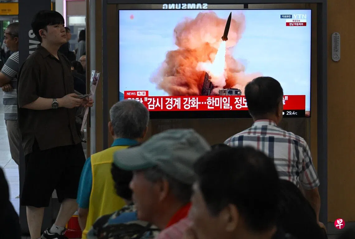 韩国军方星期四（8月20日）下午侦测到朝鲜从平壤一带向朝鲜半岛东部海域发射十多枚弹道导弹。这是朝鲜相隔八天再次发射弹道导弹，也是今年第12次。图为首尔一处火车站的民众观看电视新闻播报朝鲜导弹试射的消息。 （法新社）