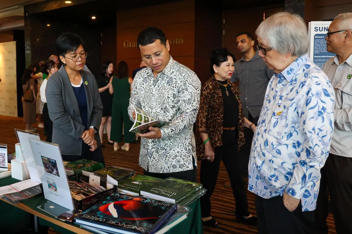 国家发展部长李智陞（前排中）和巡回大使许通美教授（前排右）星期六（10月12日）出席新加坡自然协会70周年午宴，入场前参观了自然协会在宴厅外摆放的资料。（林明顺摄）