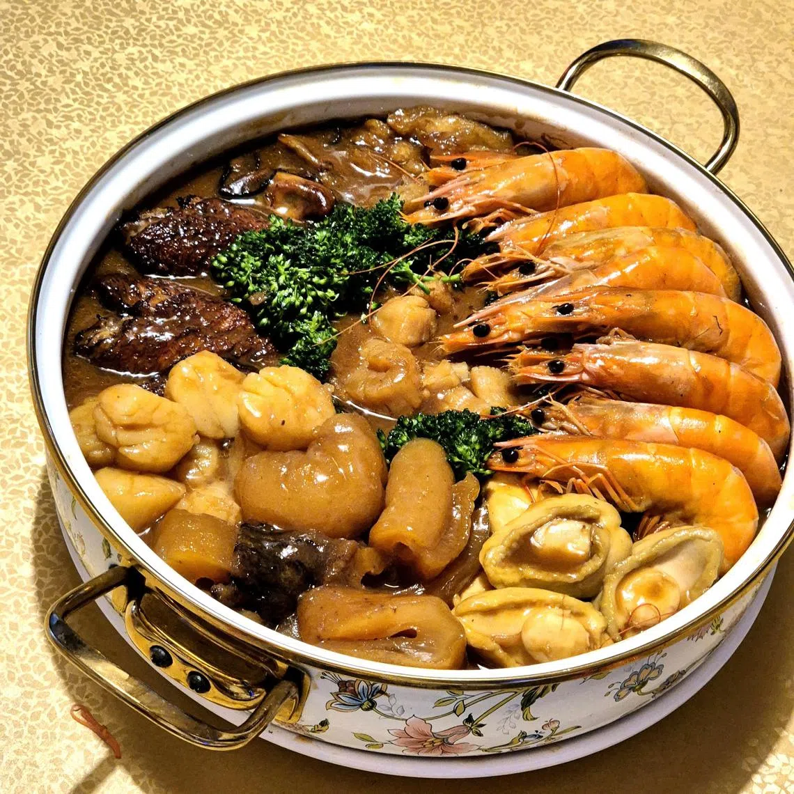 新龙兴海鲜的盆菜在接到订单后才新鲜准备，还送精美珐琅锅。（陈爱薇摄）