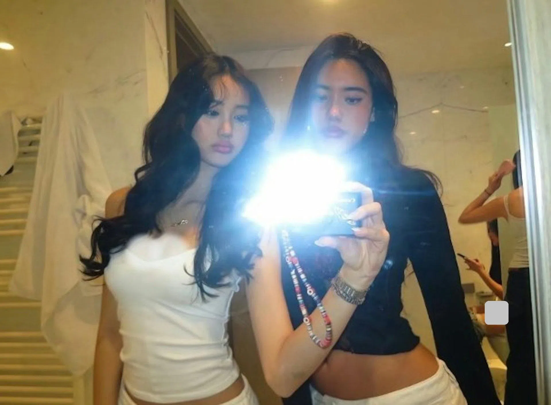 Cayla（前排左）分享与友人在洗手间对镜自拍的照片，有眼尖的网民发现两人身后有一名女子坐在马桶上。（互联网）