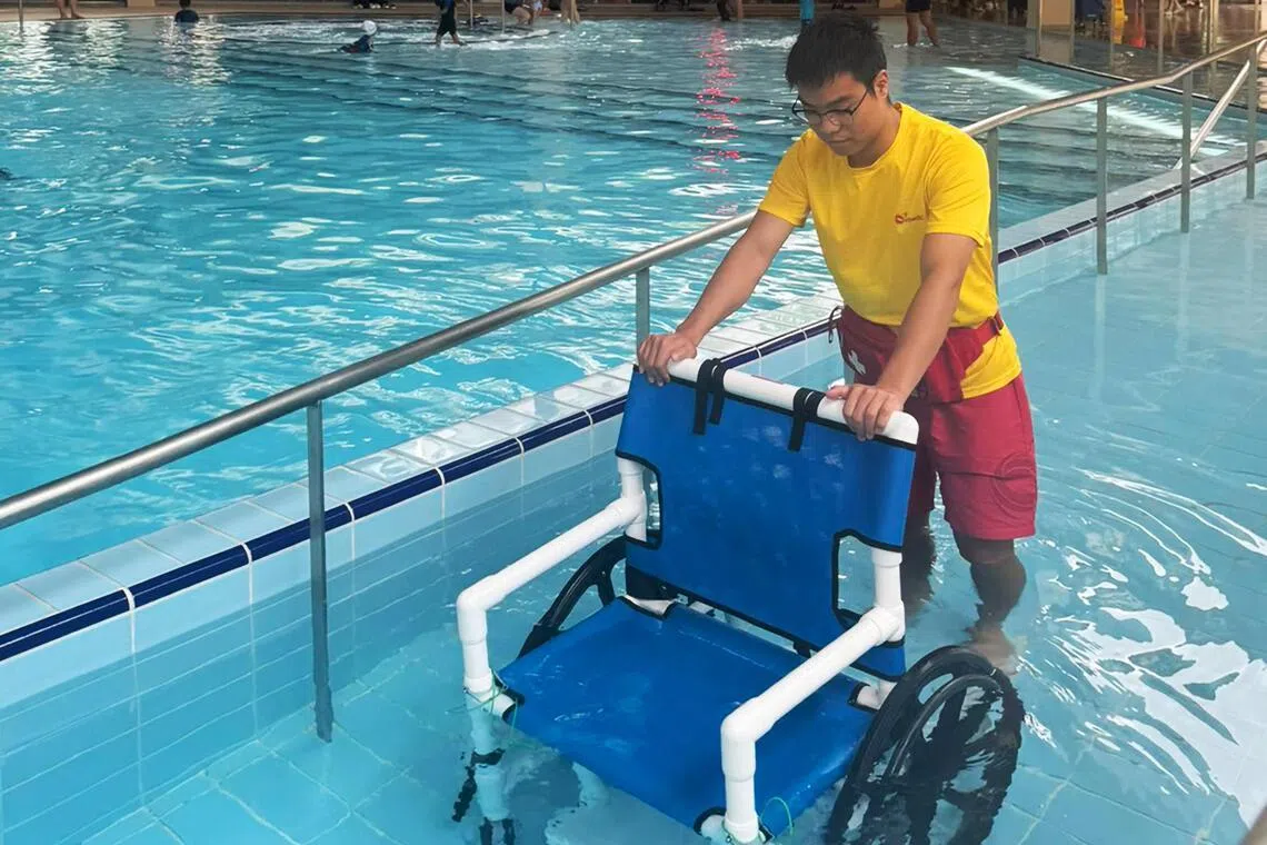 德义体育园的多世代共用泳池一侧装置了坡道，不良于行的居民可使用特制的轮椅，在旁人协助下进入泳池。（许翔宇摄）