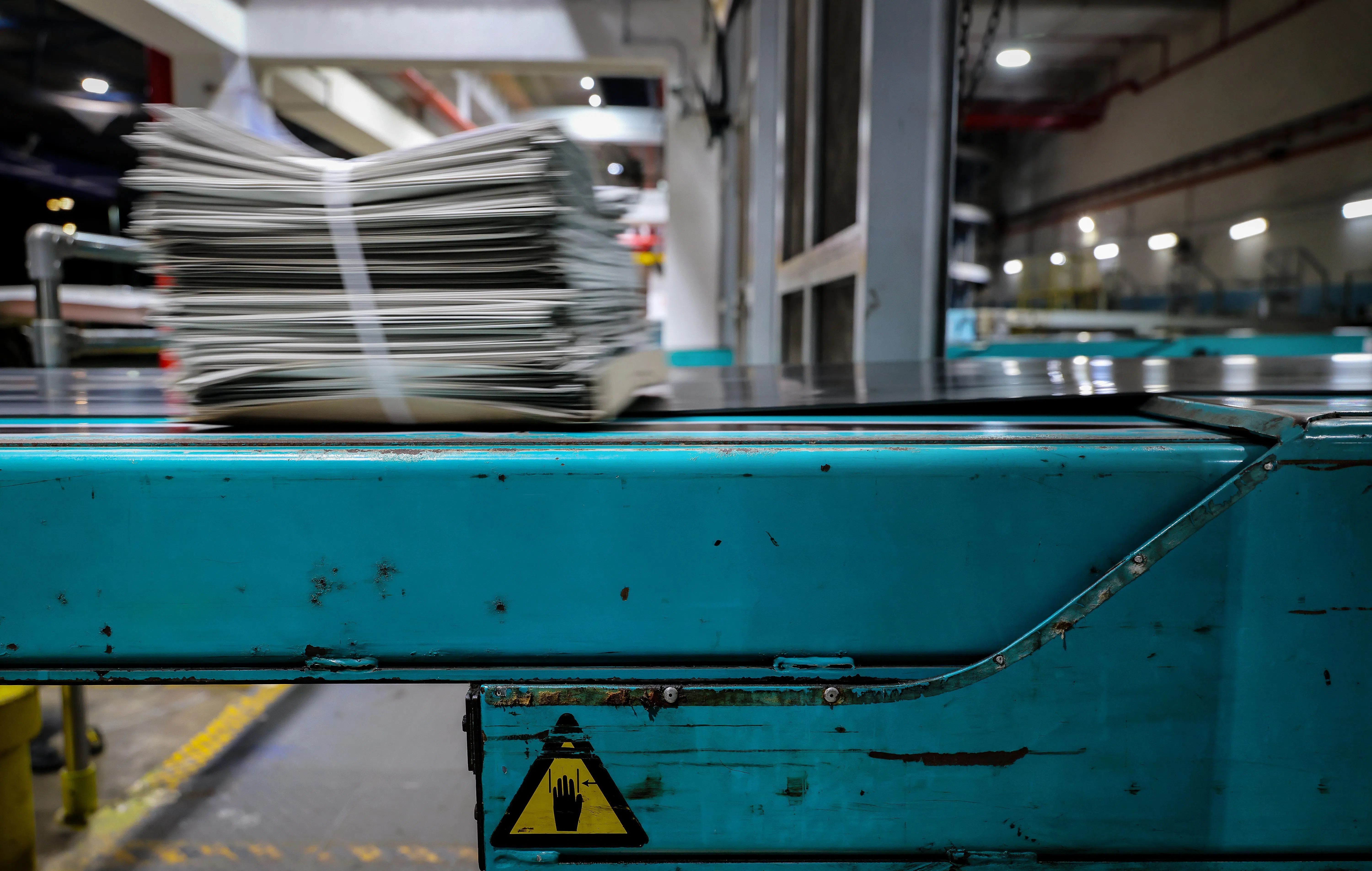 长长的机械臂输送带将报纸送上送报车。完成这最后一个步骤，报纸便踏上通往读者的新旅程。（龙国雄摄）