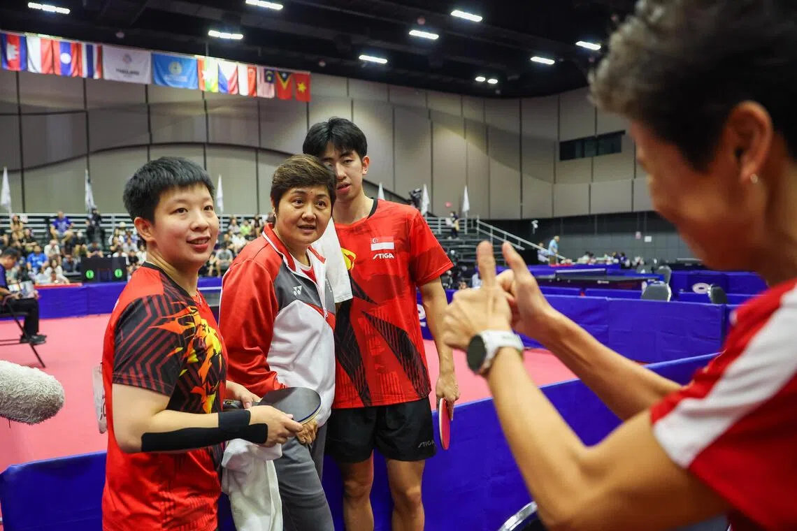新加坡乒乓球总会会长兼三巴旺集选区议员傅丽珊（右一）在曾尖（左一）和冯耀恩（右二）夺下混双金牌后，竖起拇指称赞。左二为我国乒乓球女队主教练井浚泓。（白艳琳摄）