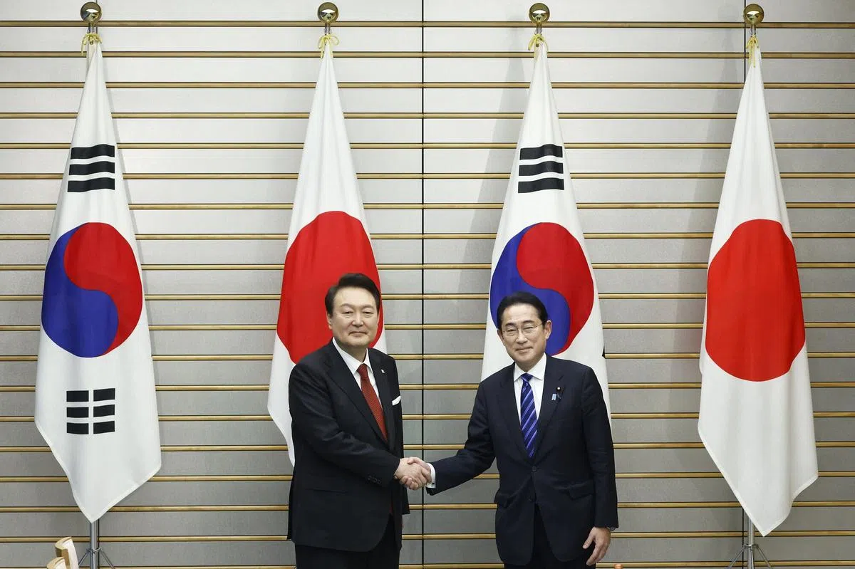 韩国总统尹锡悦（左）16日在日本首相官邸与岸田文雄举行峰会前，两人握手寒暄。（法新社）