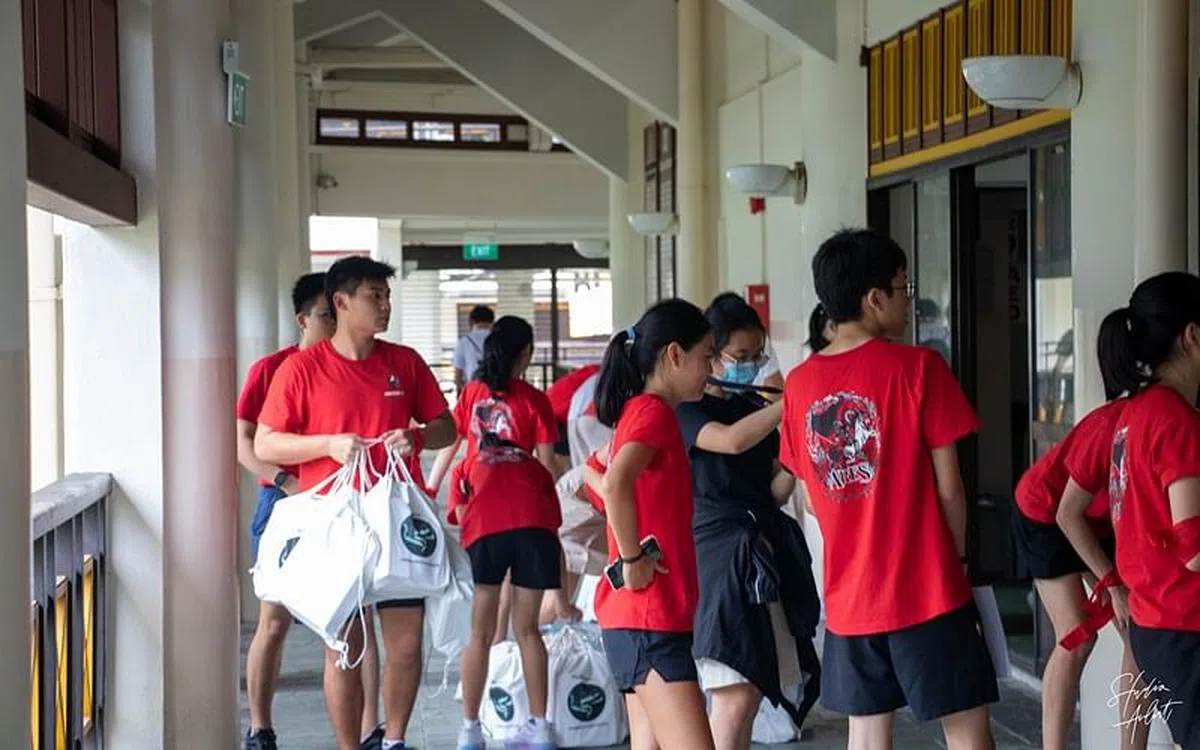 高二组长忙着搬运装有文具和零食的“礼品袋”，作为送给新生的见面礼。（华侨中学／陈靖凯摄）