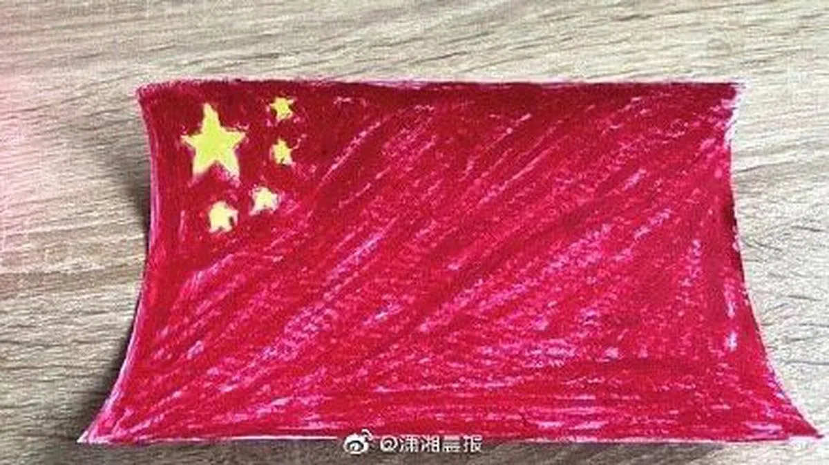 一名在乌中国人姜莱看到大使馆的通知后，用口红和荧光笔画中国国旗。（潇湘晨报）