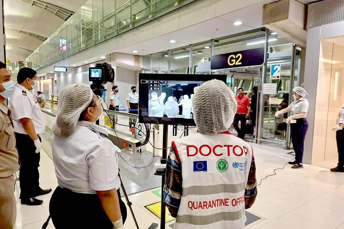 印度西孟加拉邦近期发生立百病毒人传人现象，泰国星期一（1月26日）开始对西孟加拉邦入境旅客进行体温检测，图为曼谷素万那普国际机场工作人员戴着口罩和头套等防护装备，对入境旅客进行观察和体温筛查。　（路透社）