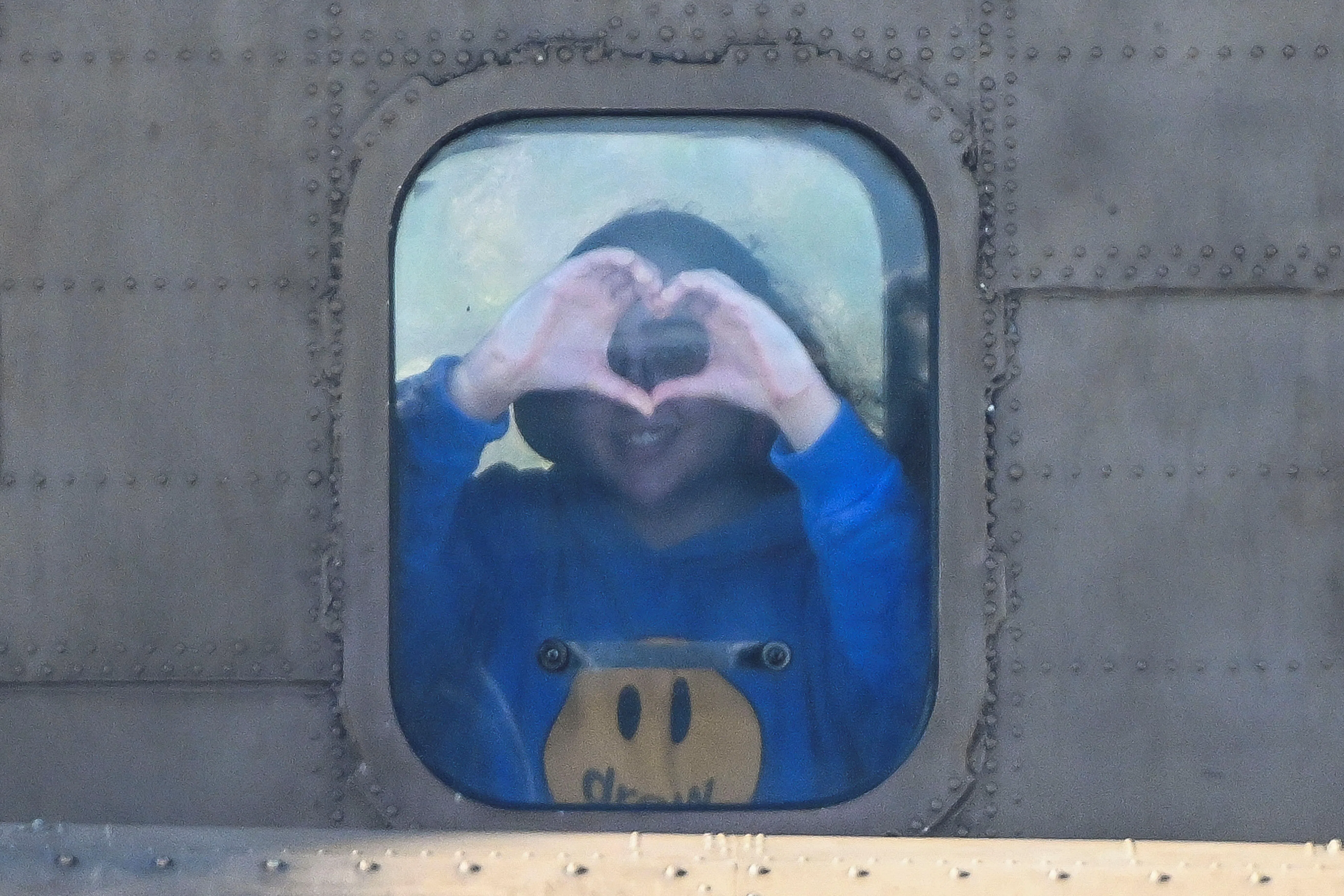 一名被释放的女兵在一架运送她和其他人质的以色列军用直升机上做了一个心形的手势。（路透社）