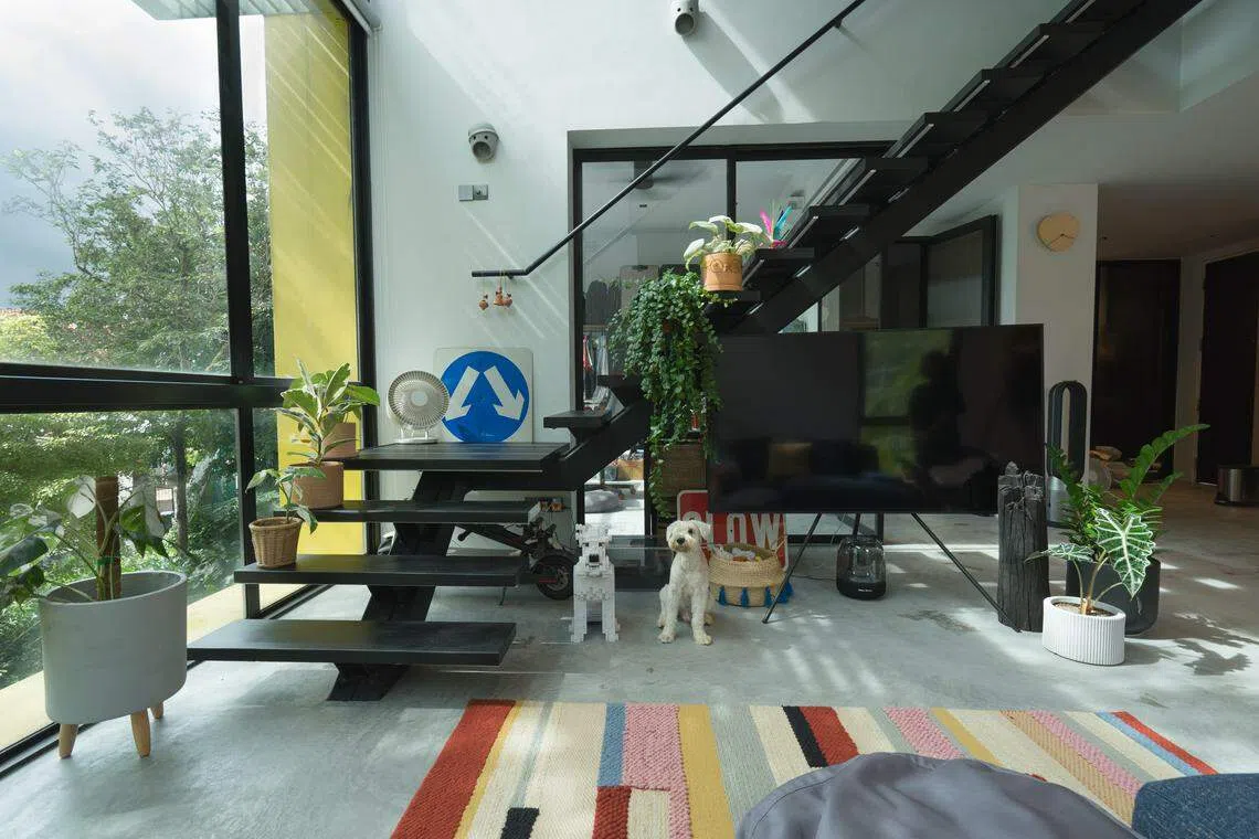 主楼层的一整片落地窗定义了房子的现代生活方式与风格，望出去是一片青葱绿意，室内由中间一道很难不成为焦点的中空楼梯分隔为左右两边。（PI Architects提供）