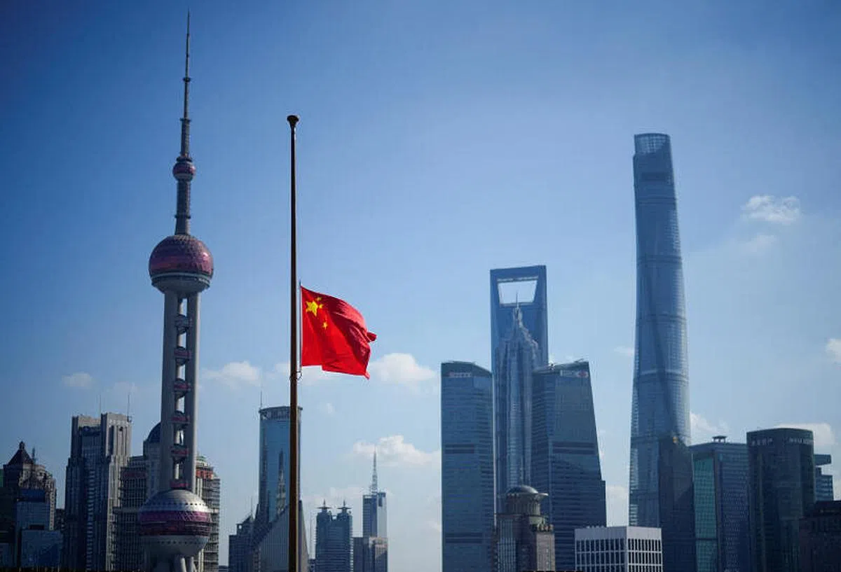 中共前总书记江泽民追悼大会12月6日上午10时在北京举行，图为上海陆家嘴金融区悬挂的国旗降半旗致哀。（路透社）