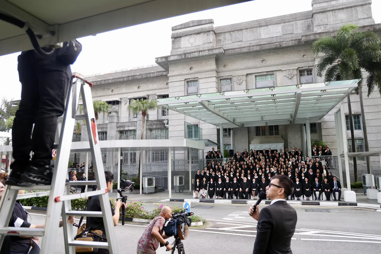 在工作人员的引导下，大法官梅达顺和家事司法法院首席法官郑慧慧与全体法官和职员在家事司法法院合乐广场原址合影，共同见证法院乔迁新址的历史时刻。（陈斌勤摄）