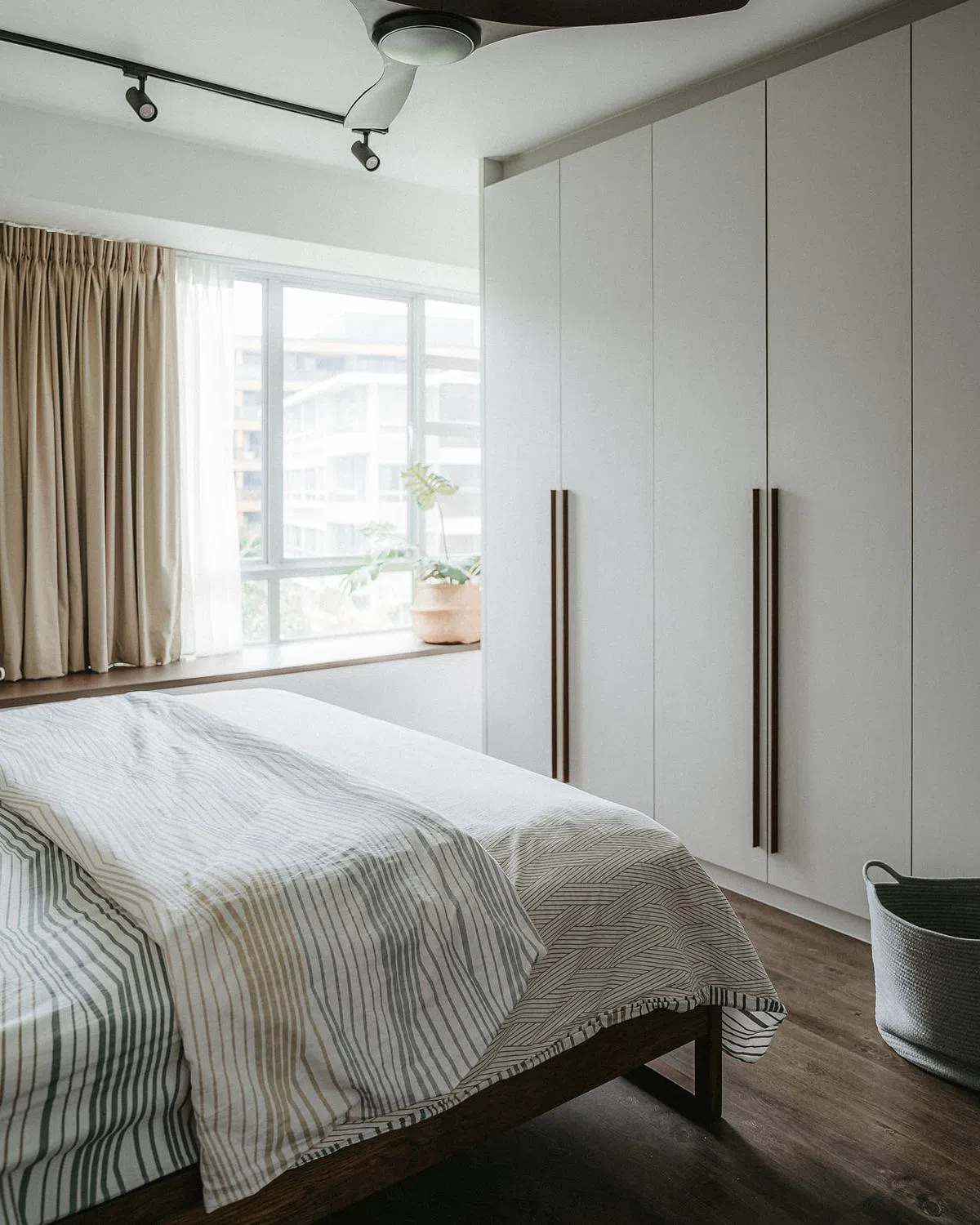 主卧室采用深色地板和白色壁橱，为屋主打造温暖惬意的安乐窝。