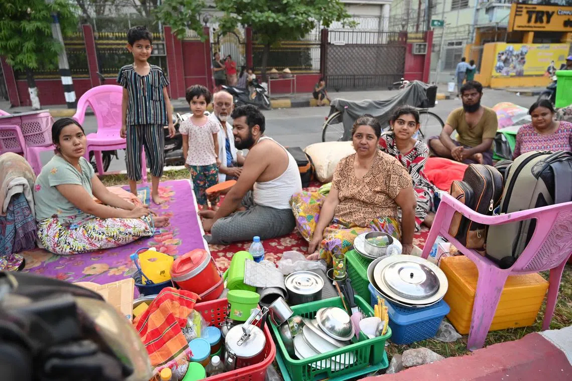 缅甸发生大地震四天后，曼德勒居民带着从家中抢救出的物品和厨具。（法新社）