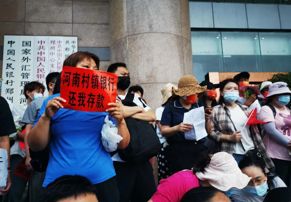 网传照片显示，民众举起标题，要求河南村镇银行归还存款。（“二月兰糯糯”微博账号）
