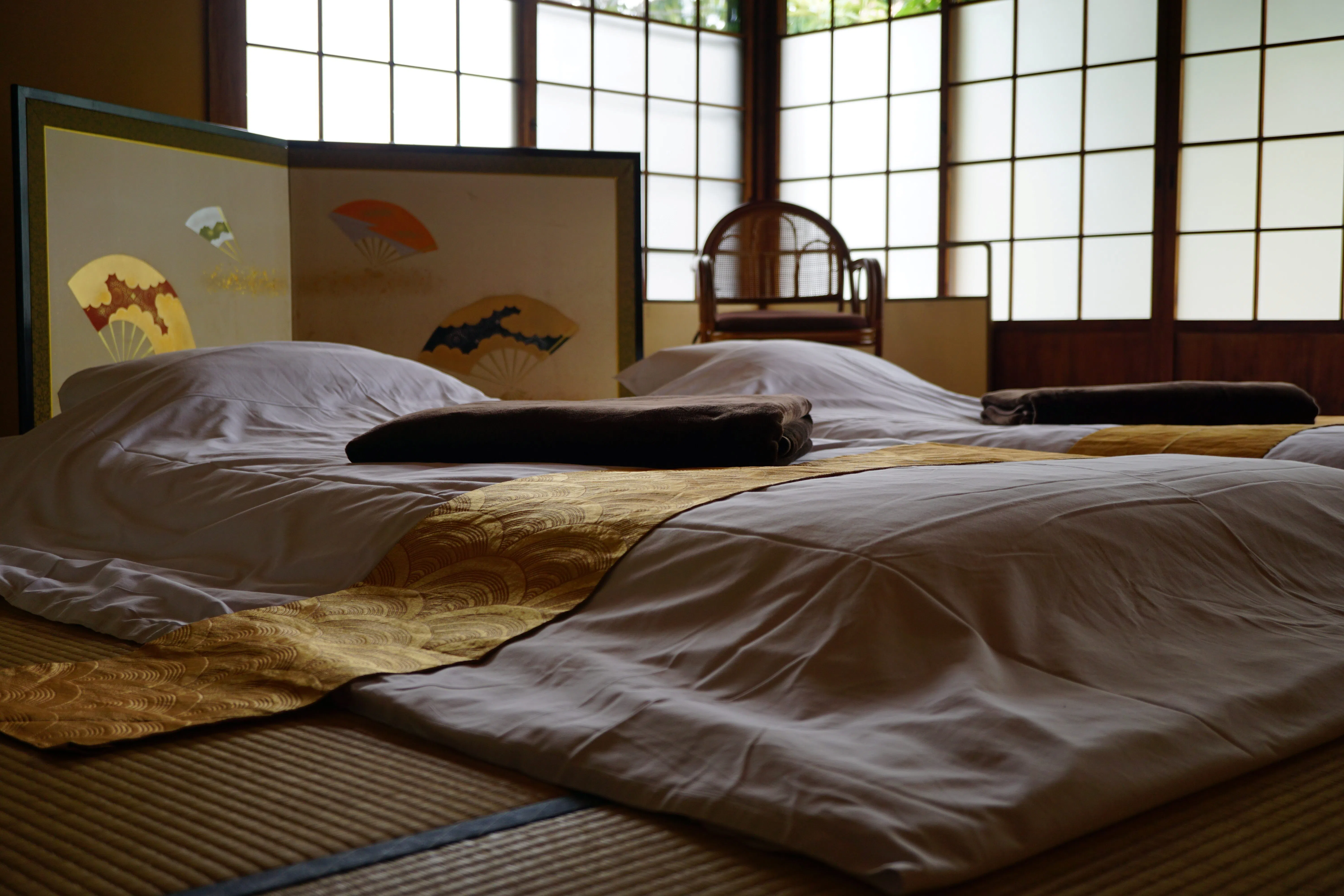 The bedding on the tatami floor is only a few steps from the graves beyond the shoji doors, all facing the same direction.（Photo: Ye Huanling）