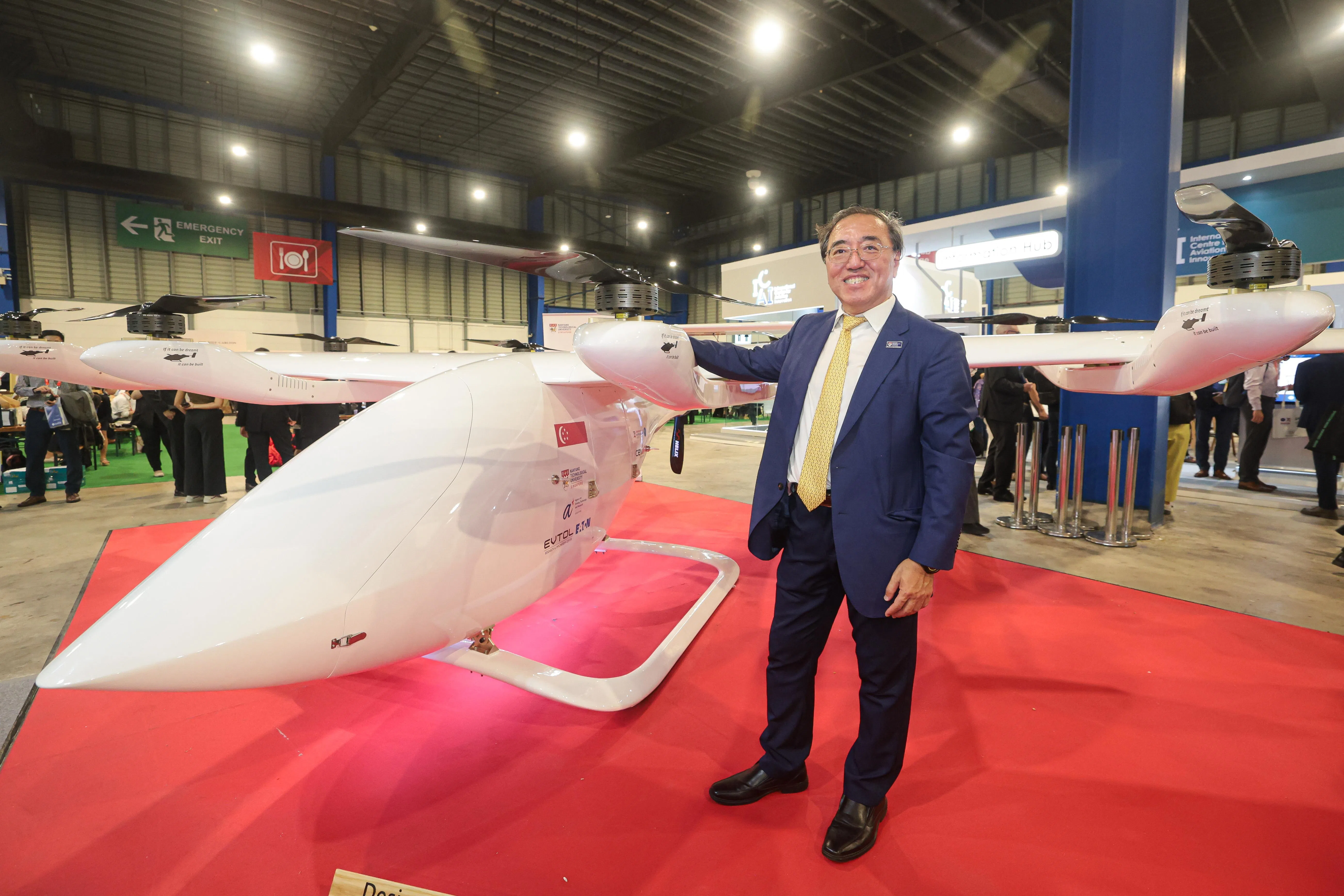 南洋理工大学机械与航空航天工程学院教授王明，在新加坡航空展现场介绍团队研发的电动垂直起降飞行器。（李冠卫摄）