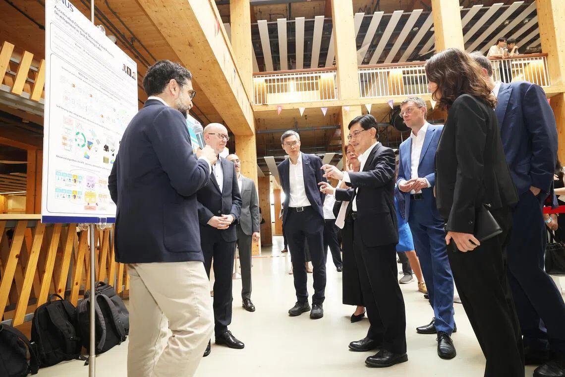 王瑞杰（右四）在签署仪式后，与马普—新加坡数据驱动化学中心研究员交流，了解他们的研究项目。（蔡家增摄）