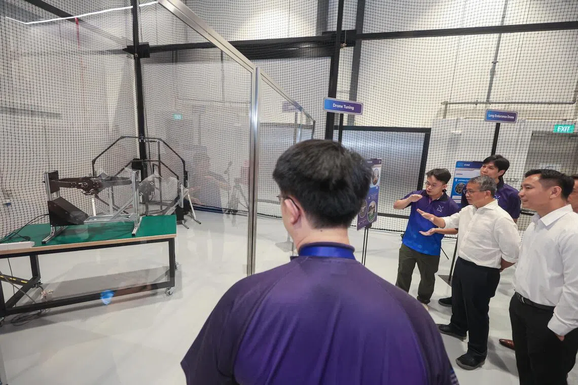 内政科技局Garage@HTX星期一（10月13日）开幕，专供内政团队科技工程师测试新技术和装备。律政部长兼内政部第二部长唐振辉（右二）和内政部兼社会及家庭发展部政务部长吴培铭（右一）参观基地内的无人机调试区域。（李冠卫摄）