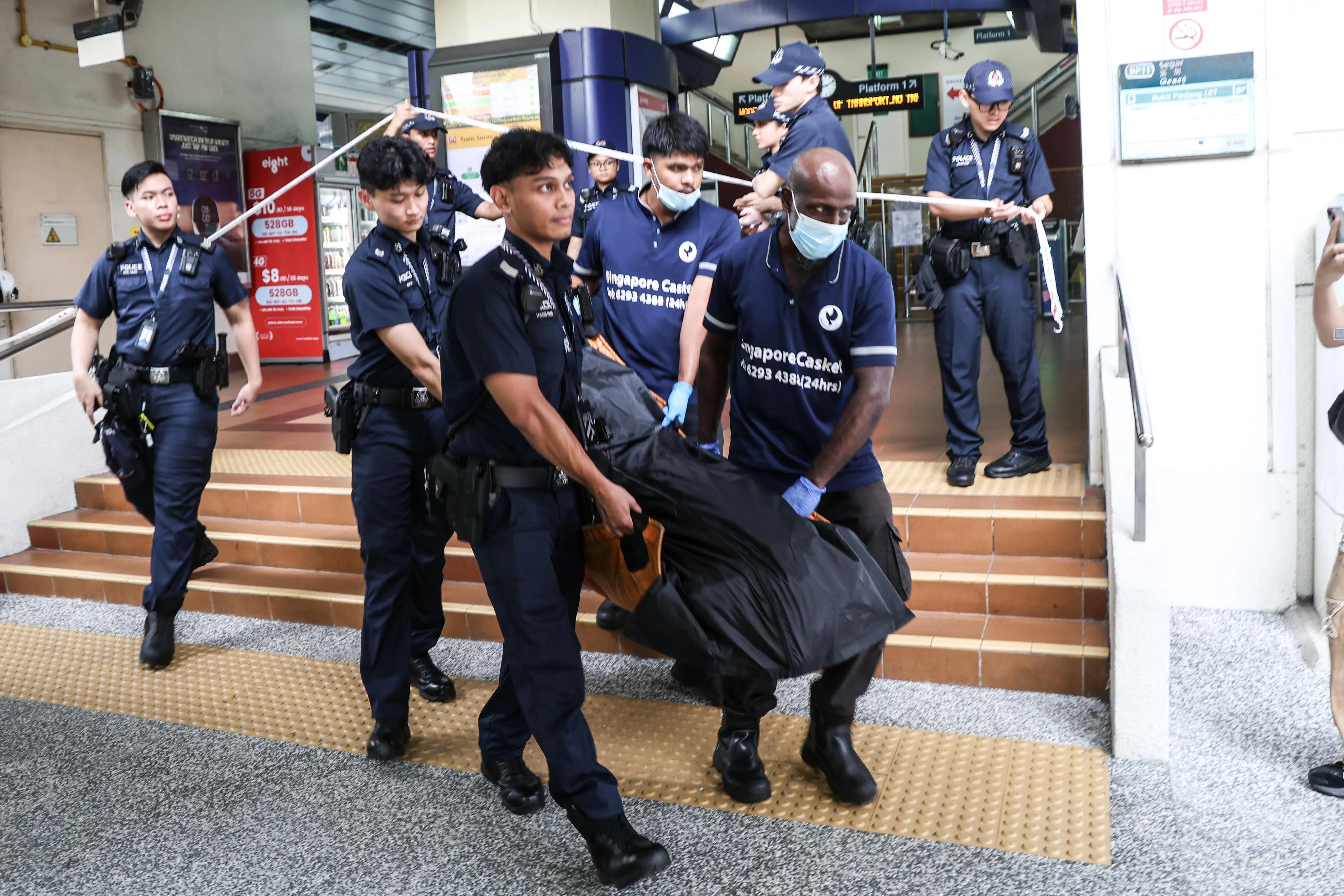 警员和仵作于早上9时16分将死者的尸体抬出轻轨站。（关俊威摄）