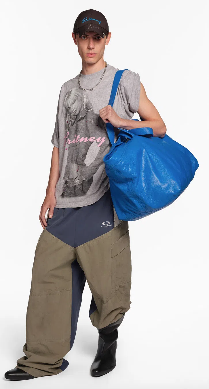 这款巴黎世家版的“宜家”皮袋会成为名留设计史的经典作。模特儿T恤上印制的布兰妮图像，是因为她是颠纳本季的缪斯。（取自品牌网站）