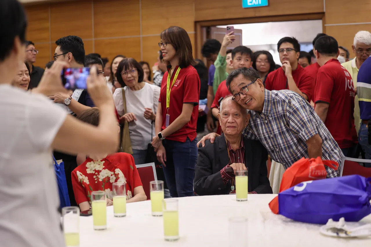 89岁的庄裕诚（坐着）是与会者中最年长的早报人，早报前总编辑林任君与他多年未见，聚会时合影留念。（白艳琳摄）