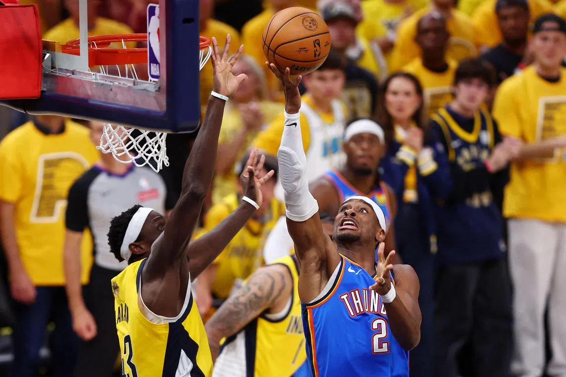 在比赛的关键时候，雷霆主将亚历山大（蓝衣）再次展现出了“大心脏”的特质，顶着对手的强硬防守连续完成得分。（法新社）