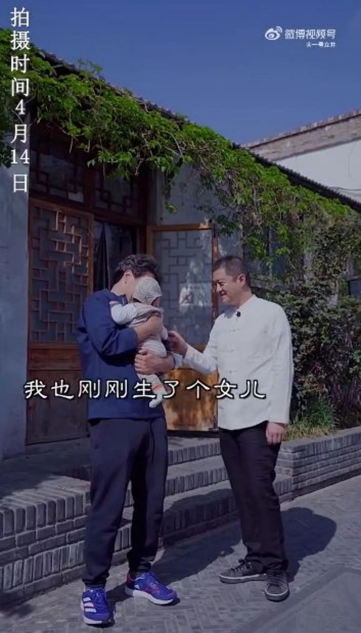 李亚鹏（白衣者）上传视频，见到外国友人抱着小娃，开心地回应自己也刚生了一个女儿，刚满一个月。（互联网）