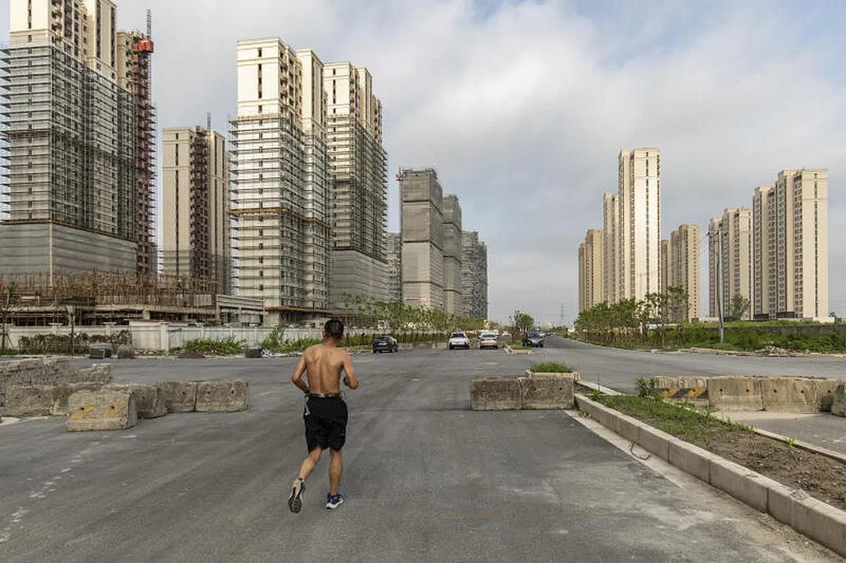 7月29日，一名市民在中国上海正在建设的住宅区附近慢跑。（彭博社）