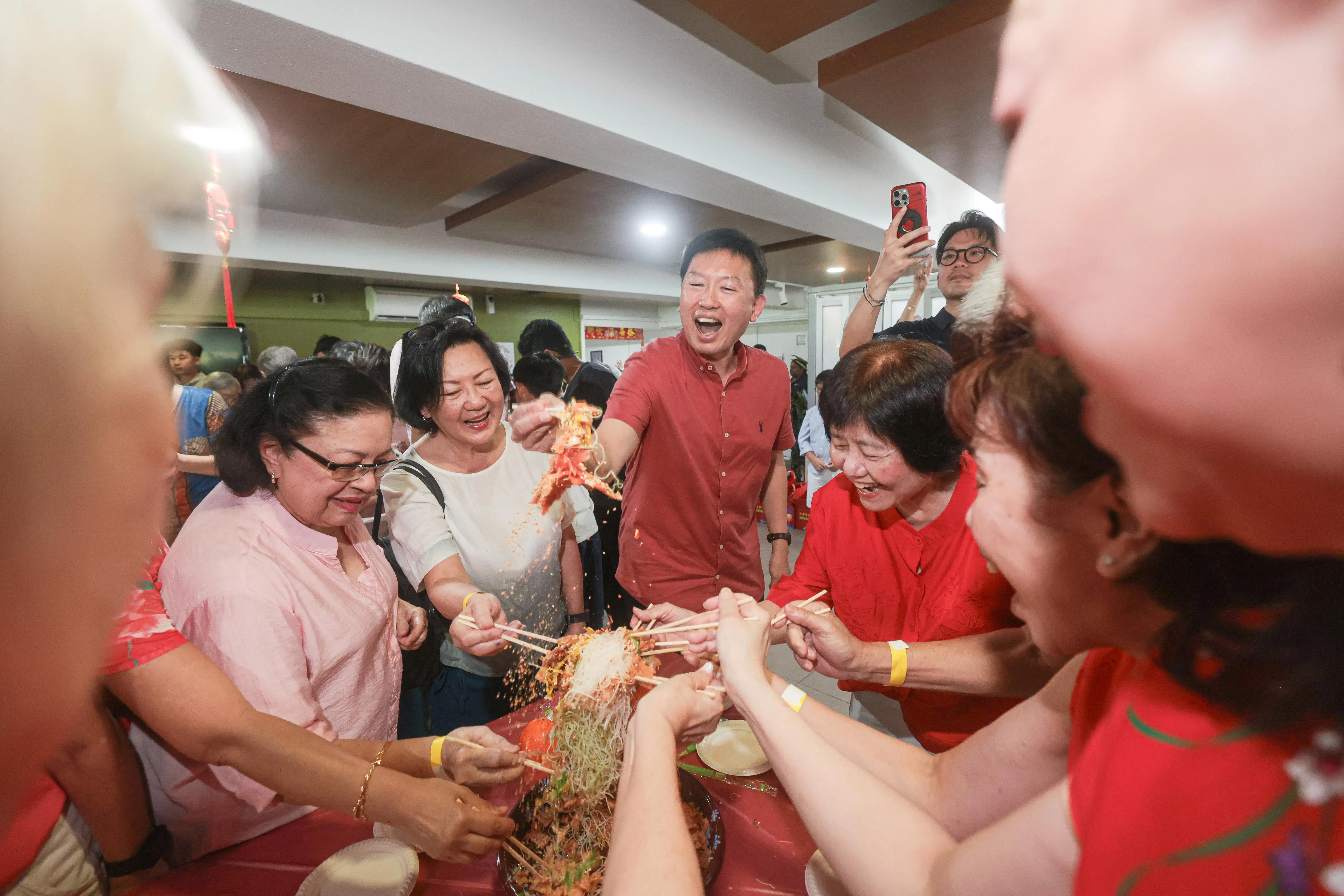国家发展部长徐芳达（中）与布莱德景公寓居民一起捞鱼生，共庆农历新年。（李冠卫摄）