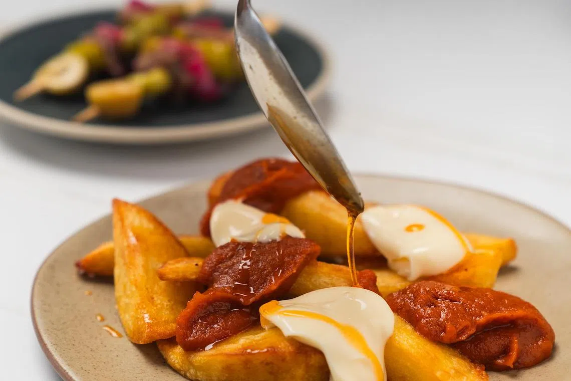 Patatas bravas bonanova是主厨最爱，马铃薯蒸煮后再油炸，外酥内绵，搭配蒜香蛋黄酱、辣番茄酱和烟熏辣椒油，风味十足。（餐馆提供）